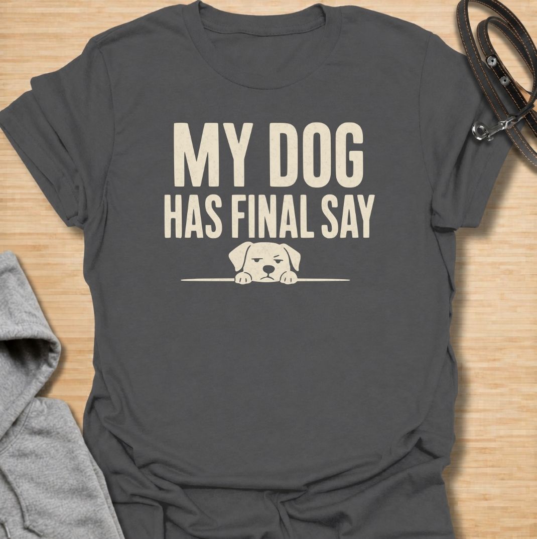 A funny dog T-shirt for anyone who knows who really makes the decisions at home. Featuring the phrase “My Dog Has Final Say” with a simple peeking dog graphic, this design captures the everyday reality of living with a very opinionated four-legged family member. Perfect for dog moms, dog dads, rescue dog owners, and anyone whose plans regularly require canine approval. A clean, playful everyday tee for fans of dog humor, funny pet sayings, and general dog lover gifts.