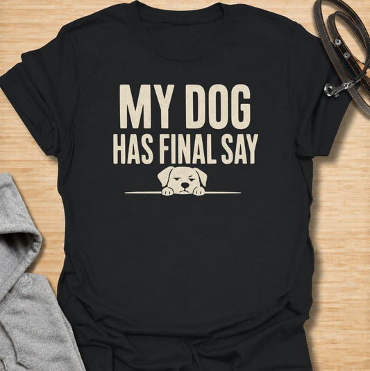 A funny dog T-shirt for anyone who knows who really makes the decisions at home. Featuring the phrase “My Dog Has Final Say” with a simple peeking dog graphic, this design captures the everyday reality of living with a very opinionated four-legged family member. Perfect for dog moms, dog dads, rescue dog owners, and anyone whose plans regularly require canine approval. A clean, playful everyday tee for fans of dog humor, funny pet sayings, and general dog lover gifts.
