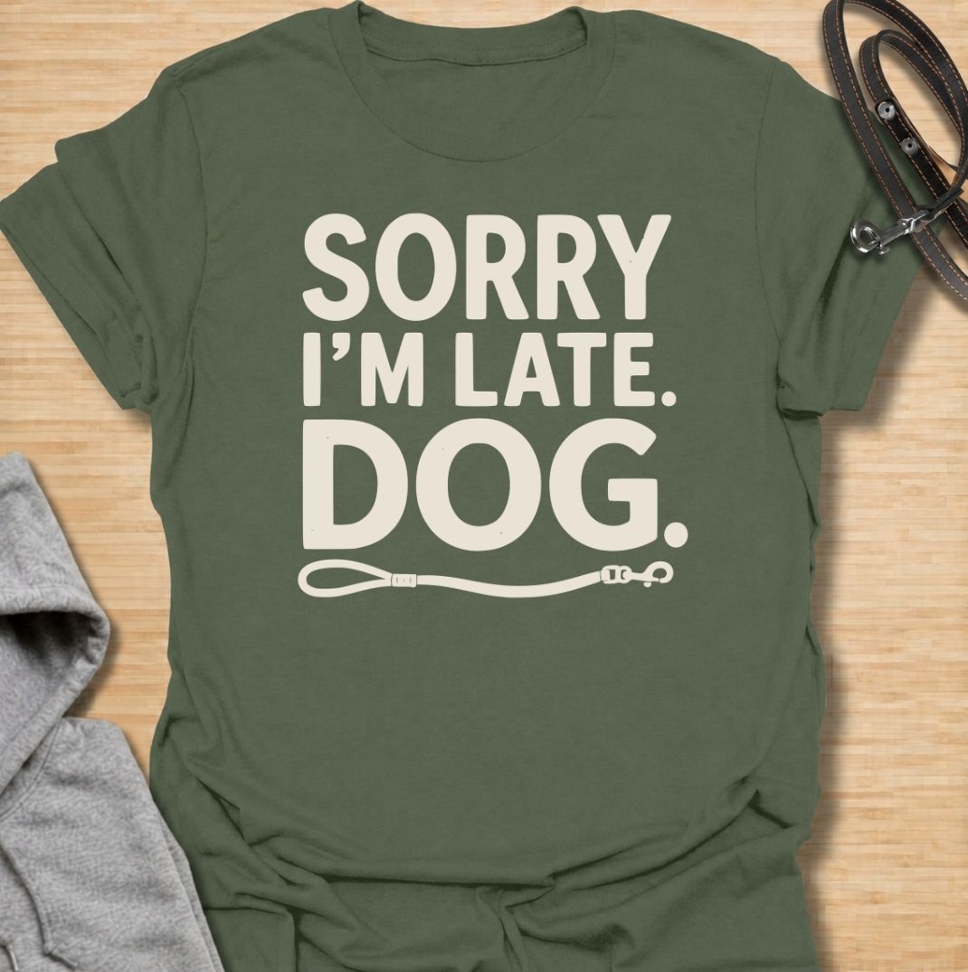 A funny dog T-shirt for anyone whose schedule is regularly dictated by walks, sniffing stops, and a four-legged companion. Featuring the phrase “Sorry I’m Late. Dog.” with a simple leash graphic, this design delivers dry, relatable dog-owner humor in a clean text-based style. Perfect for dog moms, dog dads, rescue dog owners, and anyone who has ever blamed their lateness on the dog. A playful everyday tee for fans of funny dog sayings, pet parent humor, and general dog lover gifts.