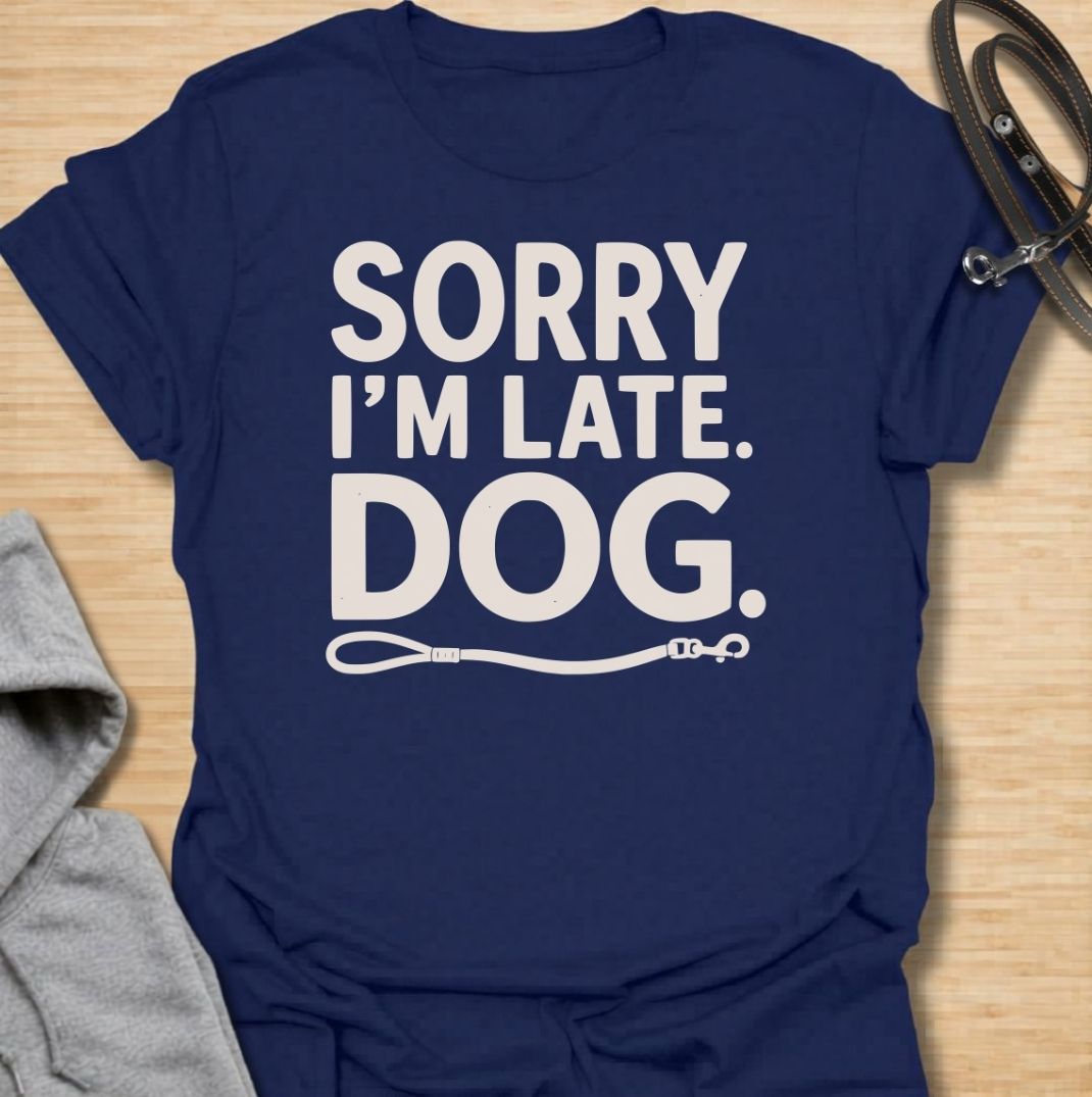A funny dog T-shirt for anyone whose schedule is regularly dictated by walks, sniffing stops, and a four-legged companion. Featuring the phrase “Sorry I’m Late. Dog.” with a simple leash graphic, this design delivers dry, relatable dog-owner humor in a clean text-based style. Perfect for dog moms, dog dads, rescue dog owners, and anyone who has ever blamed their lateness on the dog. A playful everyday tee for fans of funny dog sayings, pet parent humor, and general dog lover gifts.