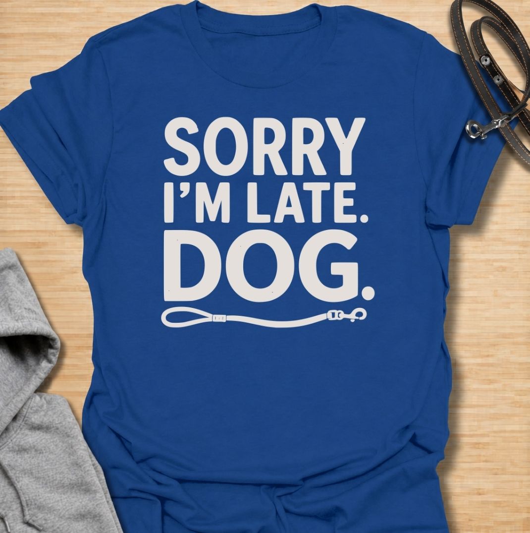 A funny dog T-shirt for anyone whose schedule is regularly dictated by walks, sniffing stops, and a four-legged companion. Featuring the phrase “Sorry I’m Late. Dog.” with a simple leash graphic, this design delivers dry, relatable dog-owner humor in a clean text-based style. Perfect for dog moms, dog dads, rescue dog owners, and anyone who has ever blamed their lateness on the dog. A playful everyday tee for fans of funny dog sayings, pet parent humor, and general dog lover gifts.