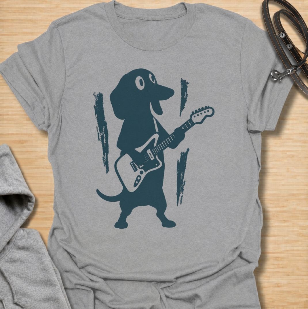 A fun dachshund T-shirt for dog lovers who know their little sausage dog has serious star power. Featuring a bold dachshund playing electric guitar, this design gives the breed a playful rock-and-roll twist without relying on text. Perfect for dachshund moms, dachshund dads, music lovers, and anyone who likes quirky breed-specific dog shirts. A strong everyday graphic tee for fans of doxies, wiener dogs, and dachshunds with big personality.