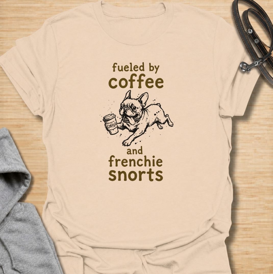 A funny French Bulldog T-shirt for anyone powered by caffeine and Frenchie chaos. Featuring the phrase “Fueled by Coffee and Frenchie Snorts” with a playful French Bulldog carrying a coffee cup, this design combines two everyday favorites in one lighthearted graphic. Perfect for Frenchie moms, Frenchie dads, coffee lovers, and anyone familiar with those unmistakable bulldog snorts. A fun everyday tee for fans of French Bulldog humor, coffee jokes, and breed-specific dog gifts.