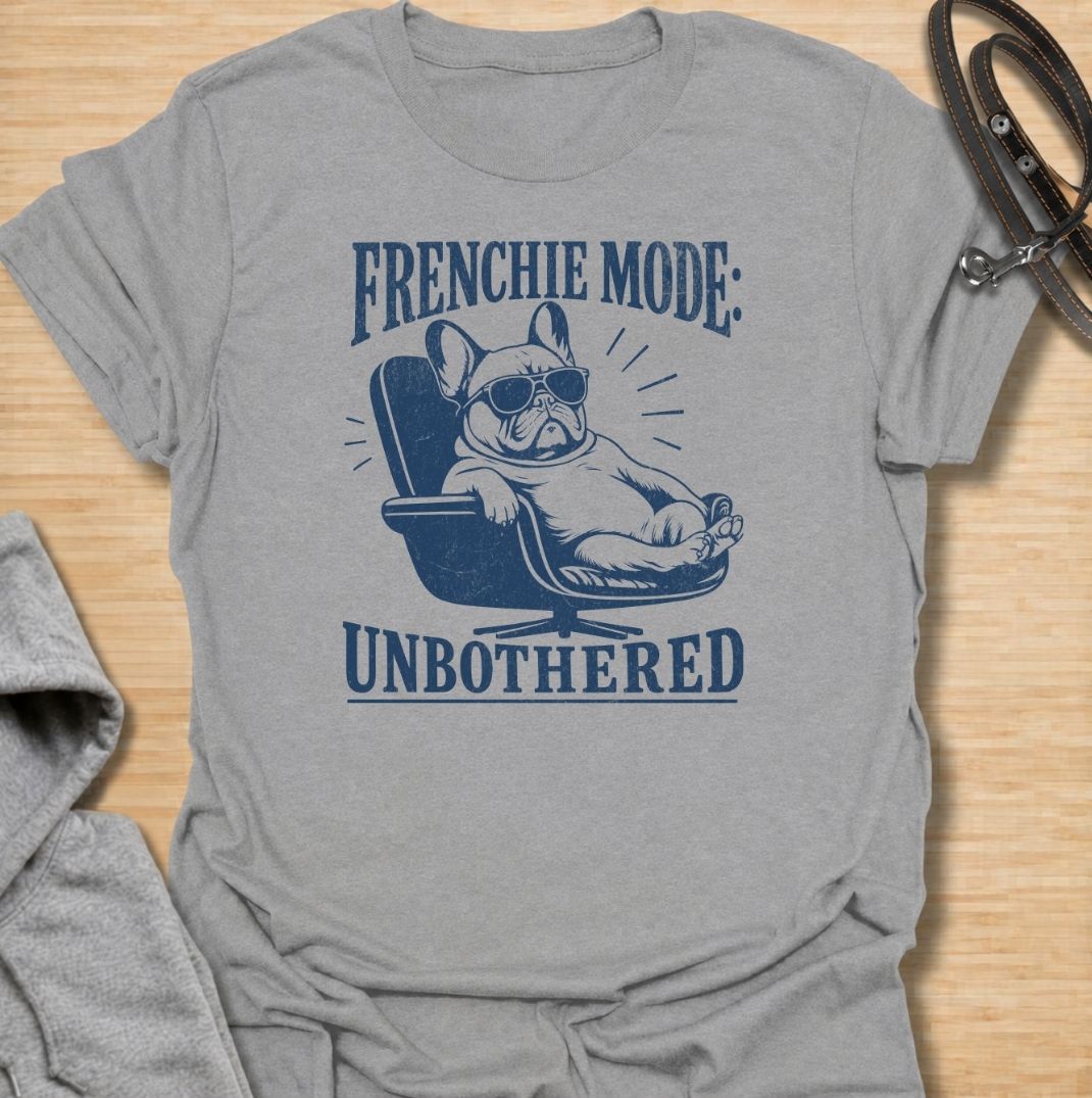 A funny French Bulldog T-shirt for anyone who knows a Frenchie can look completely relaxed while ignoring everything around them. Featuring the phrase “Frenchie Mode: Unbothered” with a laid-back bulldog illustration, this design captures the breed’s cool, stubborn personality perfectly. Ideal for Frenchie moms, Frenchie dads, bulldog lovers, and anyone who appreciates a dog with attitude. A playful everyday tee for fans of French Bulldog humor, relaxed dog vibes, and breed-specific gifts.