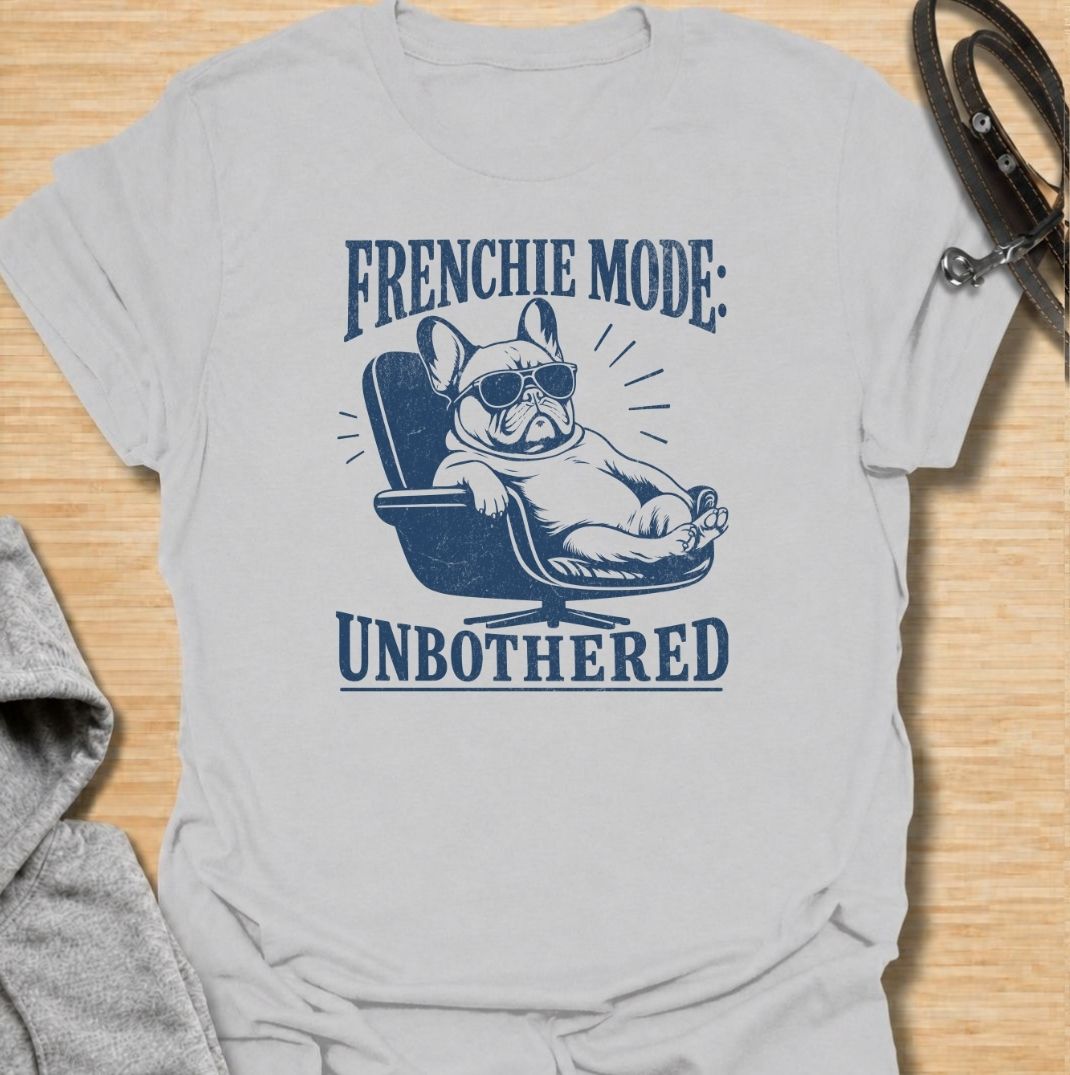 A funny French Bulldog T-shirt for anyone who knows a Frenchie can look completely relaxed while ignoring everything around them. Featuring the phrase “Frenchie Mode: Unbothered” with a laid-back bulldog illustration, this design captures the breed’s cool, stubborn personality perfectly. Ideal for Frenchie moms, Frenchie dads, bulldog lovers, and anyone who appreciates a dog with attitude. A playful everyday tee for fans of French Bulldog humor, relaxed dog vibes, and breed-specific gifts.