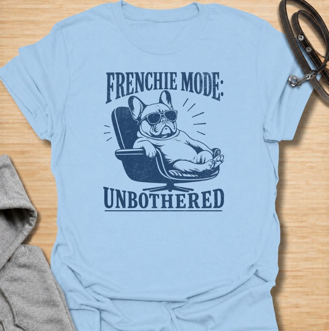 A funny French Bulldog T-shirt for anyone who knows a Frenchie can look completely relaxed while ignoring everything around them. Featuring the phrase “Frenchie Mode: Unbothered” with a laid-back bulldog illustration, this design captures the breed’s cool, stubborn personality perfectly. Ideal for Frenchie moms, Frenchie dads, bulldog lovers, and anyone who appreciates a dog with attitude. A playful everyday tee for fans of French Bulldog humor, relaxed dog vibes, and breed-specific gifts.