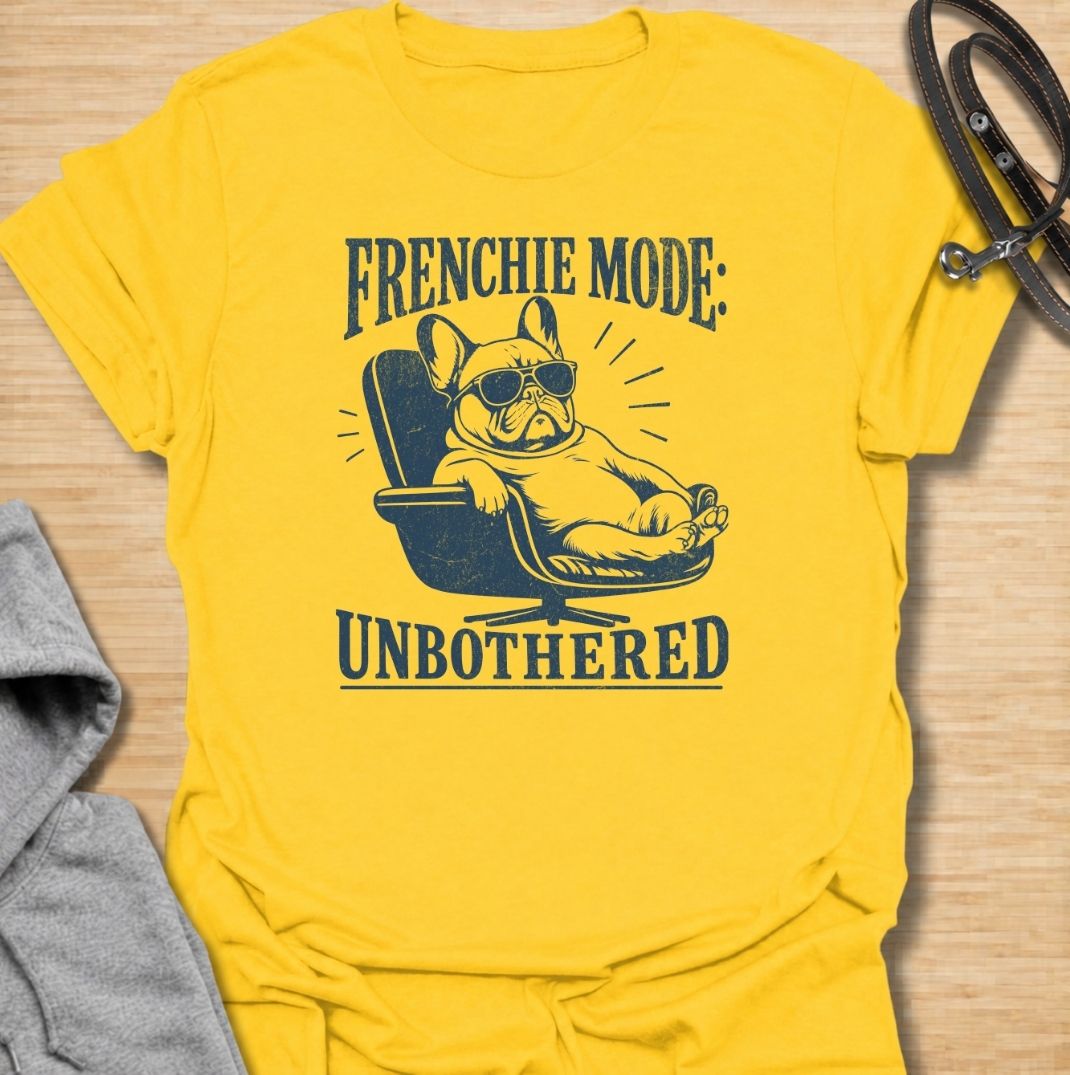 A funny French Bulldog T-shirt for anyone who knows a Frenchie can look completely relaxed while ignoring everything around them. Featuring the phrase “Frenchie Mode: Unbothered” with a laid-back bulldog illustration, this design captures the breed’s cool, stubborn personality perfectly. Ideal for Frenchie moms, Frenchie dads, bulldog lovers, and anyone who appreciates a dog with attitude. A playful everyday tee for fans of French Bulldog humor, relaxed dog vibes, and breed-specific gifts.