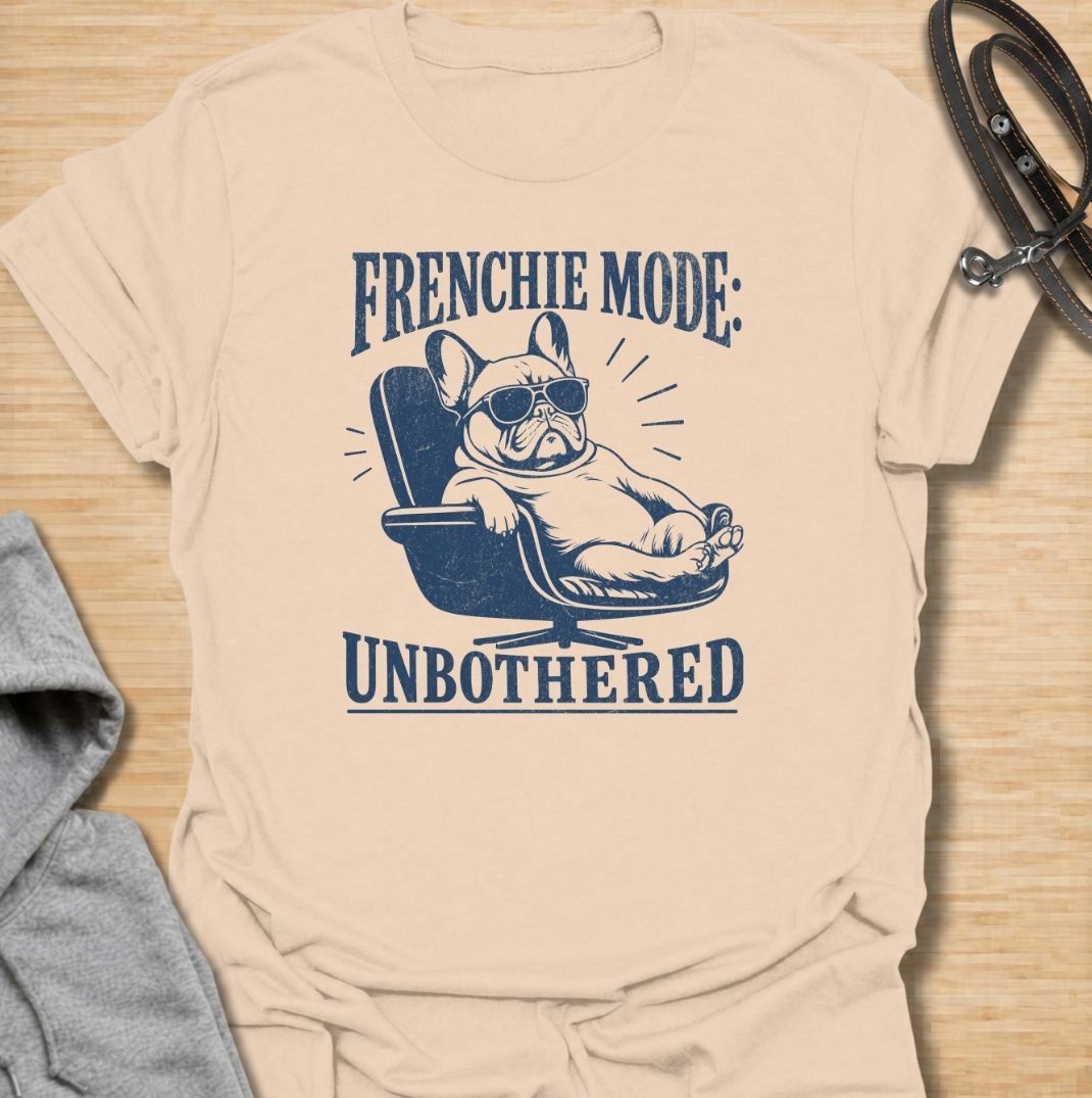 A funny French Bulldog T-shirt for anyone who knows a Frenchie can look completely relaxed while ignoring everything around them. Featuring the phrase “Frenchie Mode: Unbothered” with a laid-back bulldog illustration, this design captures the breed’s cool, stubborn personality perfectly. Ideal for Frenchie moms, Frenchie dads, bulldog lovers, and anyone who appreciates a dog with attitude. A playful everyday tee for fans of French Bulldog humor, relaxed dog vibes, and breed-specific gifts.