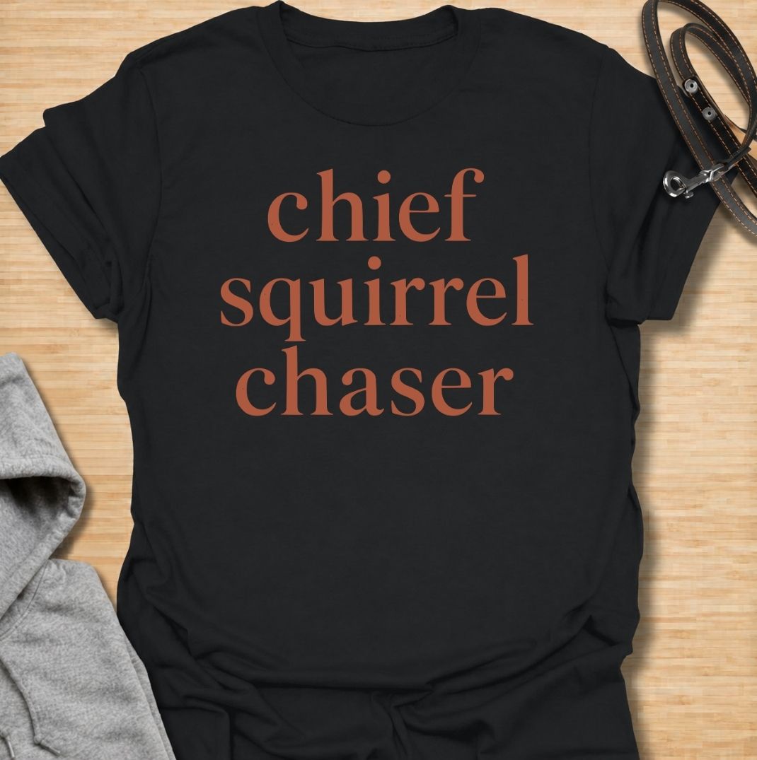 A funny dog T-shirt for anyone whose dog takes squirrel patrol very seriously. Featuring the phrase “Chief Squirrel Chaser” in a clean, bold text-only design, this shirt is perfect for dogs who treat every backyard visitor like an emergency. Ideal for dog moms, dog dads, rescue dog owners, and anyone familiar with sudden squirrel-fueled chaos. A simple everyday tee for fans of dog humor, playful pet sayings, and general dog lover gifts.