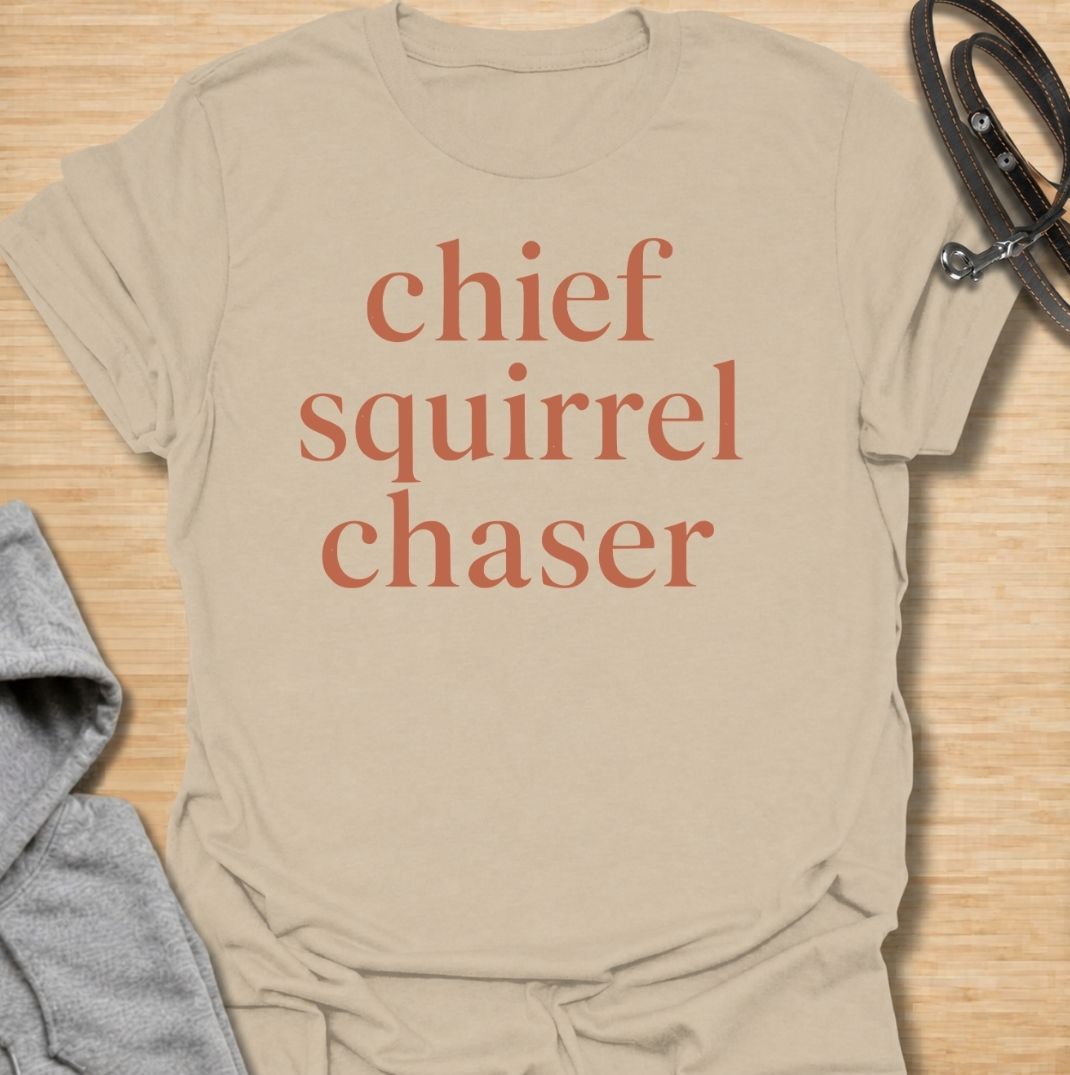 A funny dog T-shirt for anyone whose dog takes squirrel patrol very seriously. Featuring the phrase “Chief Squirrel Chaser” in a clean, bold text-only design, this shirt is perfect for dogs who treat every backyard visitor like an emergency. Ideal for dog moms, dog dads, rescue dog owners, and anyone familiar with sudden squirrel-fueled chaos. A simple everyday tee for fans of dog humor, playful pet sayings, and general dog lover gifts.
