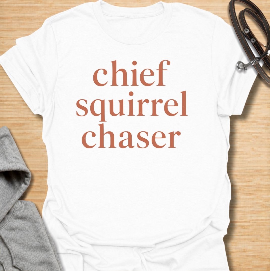 A funny dog T-shirt for anyone whose dog takes squirrel patrol very seriously. Featuring the phrase “Chief Squirrel Chaser” in a clean, bold text-only design, this shirt is perfect for dogs who treat every backyard visitor like an emergency. Ideal for dog moms, dog dads, rescue dog owners, and anyone familiar with sudden squirrel-fueled chaos. A simple everyday tee for fans of dog humor, playful pet sayings, and general dog lover gifts.