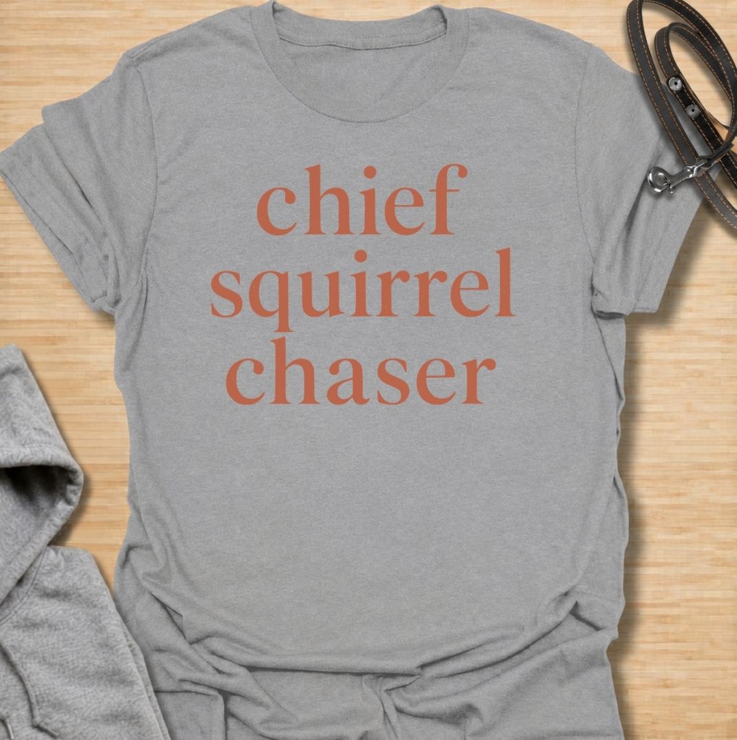 A funny dog T-shirt for anyone whose dog takes squirrel patrol very seriously. Featuring the phrase “Chief Squirrel Chaser” in a clean, bold text-only design, this shirt is perfect for dogs who treat every backyard visitor like an emergency. Ideal for dog moms, dog dads, rescue dog owners, and anyone familiar with sudden squirrel-fueled chaos. A simple everyday tee for fans of dog humor, playful pet sayings, and general dog lover gifts.
