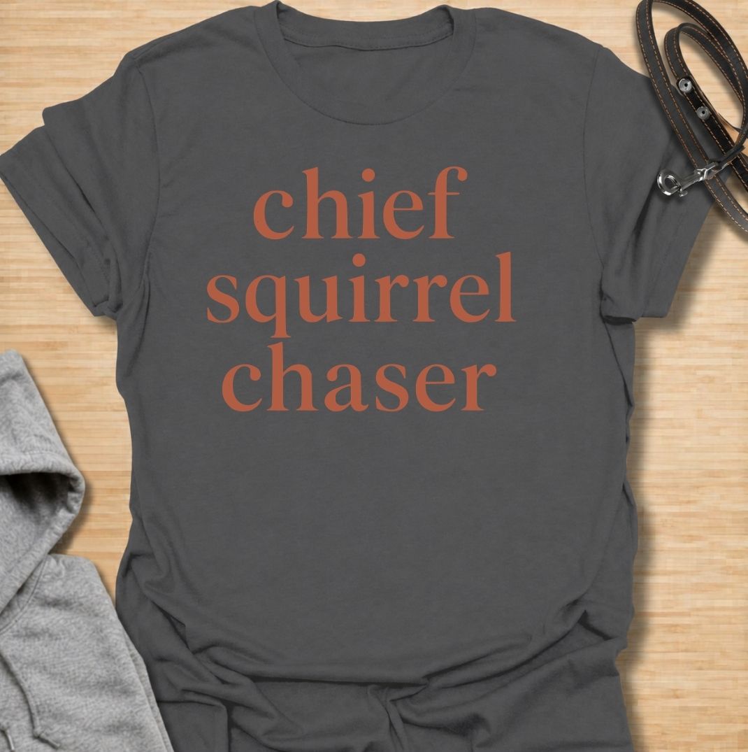 A funny dog T-shirt for anyone whose dog takes squirrel patrol very seriously. Featuring the phrase “Chief Squirrel Chaser” in a clean, bold text-only design, this shirt is perfect for dogs who treat every backyard visitor like an emergency. Ideal for dog moms, dog dads, rescue dog owners, and anyone familiar with sudden squirrel-fueled chaos. A simple everyday tee for fans of dog humor, playful pet sayings, and general dog lover gifts.