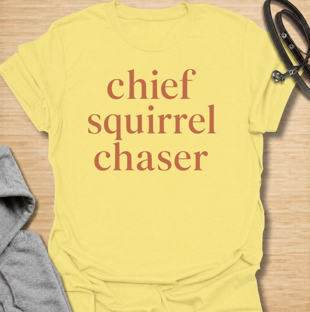 A funny dog T-shirt for anyone whose dog takes squirrel patrol very seriously. Featuring the phrase “Chief Squirrel Chaser” in a clean, bold text-only design, this shirt is perfect for dogs who treat every backyard visitor like an emergency. Ideal for dog moms, dog dads, rescue dog owners, and anyone familiar with sudden squirrel-fueled chaos. A simple everyday tee for fans of dog humor, playful pet sayings, and general dog lover gifts.