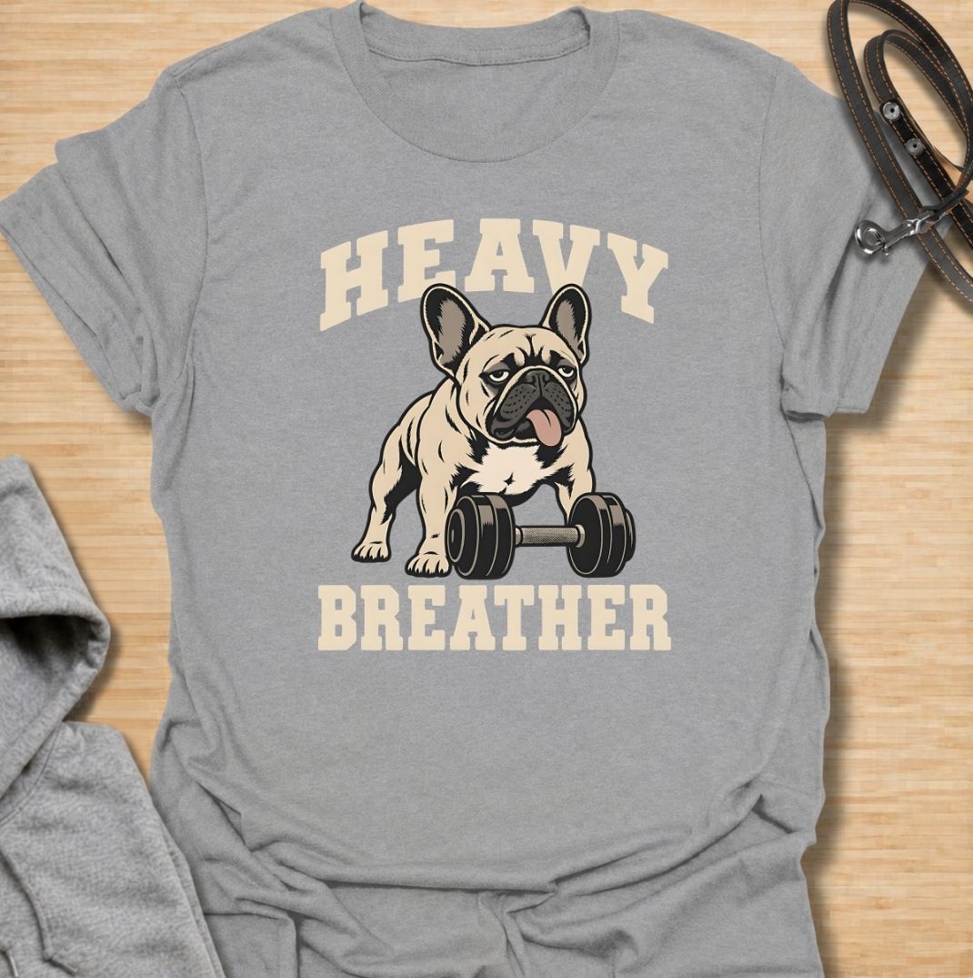 A funny French Bulldog T-shirt for anyone who knows a Frenchie can sound like they’ve finished a workout before it has even started. Featuring the phrase “Heavy Breather” with a French Bulldog and dumbbell graphic, this design combines gym humor with one of the breed’s most recognizable traits. Perfect for Frenchie moms, Frenchie dads, gym lovers, and anyone who enjoys breed-specific dog humor. A playful everyday tee for fans of French Bulldog fitness jokes, funny dog shirts, and unique Frenchie gifts.
