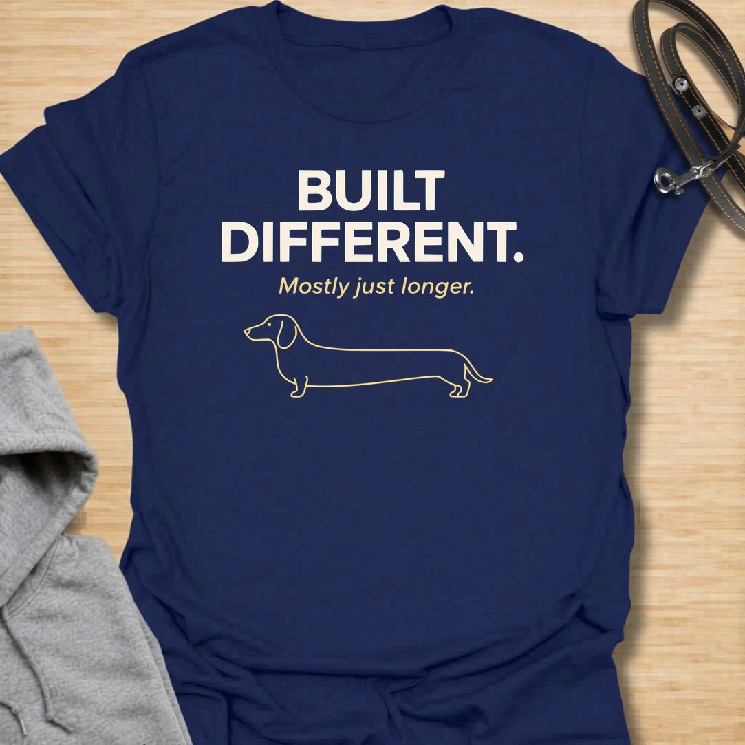 This Built Different Mostly Just Longer t-shirt is made for dachshund lovers who know their little long dog has a body shape like no other. Featuring clean bold typography, a minimal dachshund line illustration, and a funny breed-specific punchline, this design has a simple modern dog-parent feel that doxie owners will instantly understand. Perfect for dachshund moms, dachshund dads, wiener dog fans, rescue dog lovers, and anyone who loves a tiny-legged dog with a very long personality.