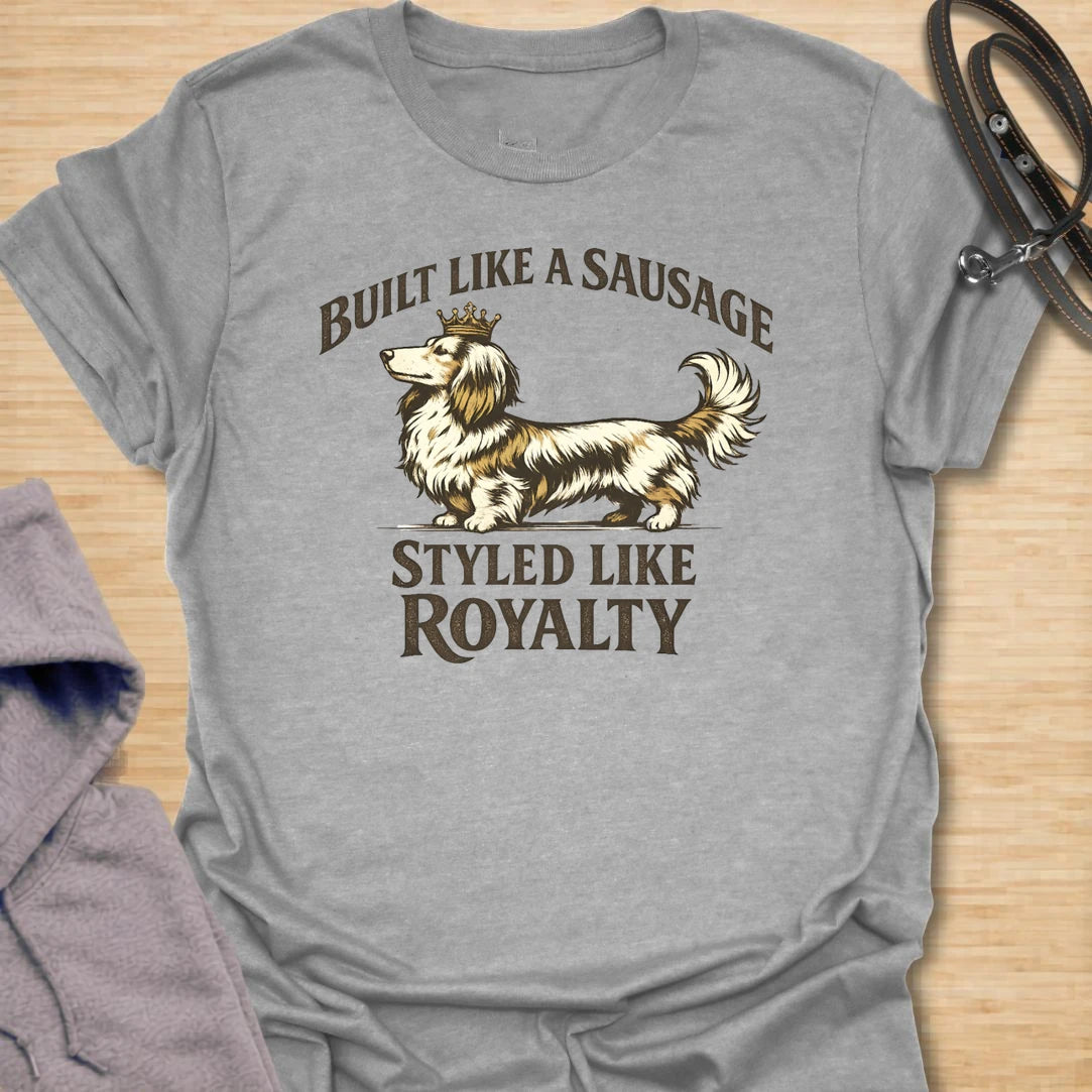 This Built Like A Sausage Styled Like Royalty t-shirt is made for long-haired dachshund lovers who know their little dog has a funny shape and a very grand sense of self. Featuring an elegant long-haired doxie with a tiny crown and bold vintage-style lettering, this design has a polished breed-specific feel with plenty of humor. Perfect for dachshund moms, dachshund dads, long-haired doxie fans, wiener dog lovers, and anyone whose sausage dog