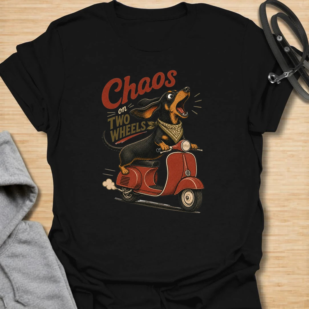 Chaos on two wheels dachshund t-shirt for anyone whose sausage dog seems to manage the household mayhem. This funny vintage-style design features a bold dachshund racing along on a scooter with retro lettering and plenty of doxie attitude. Perfect for dachshund moms, doxie dads, wiener dog lovers, and small dog owners who know chaos is part of the charm.