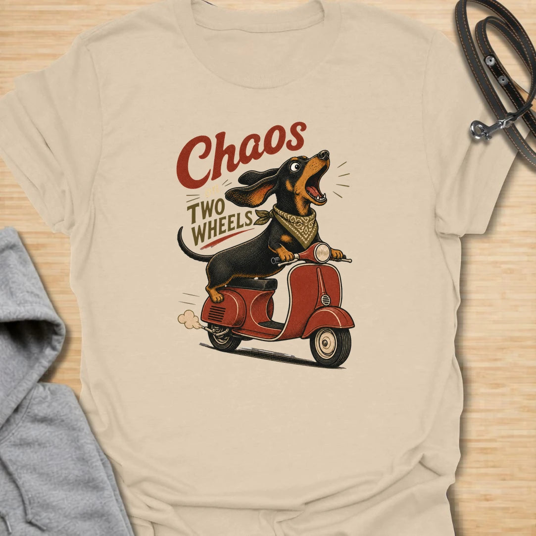 Chaos on two wheels dachshund t-shirt for anyone whose sausage dog seems to manage the household mayhem. This funny vintage-style design features a bold dachshund racing along on a scooter with retro lettering and plenty of doxie attitude. Perfect for dachshund moms, doxie dads, wiener dog lovers, and small dog owners who know chaos is part of the charm.