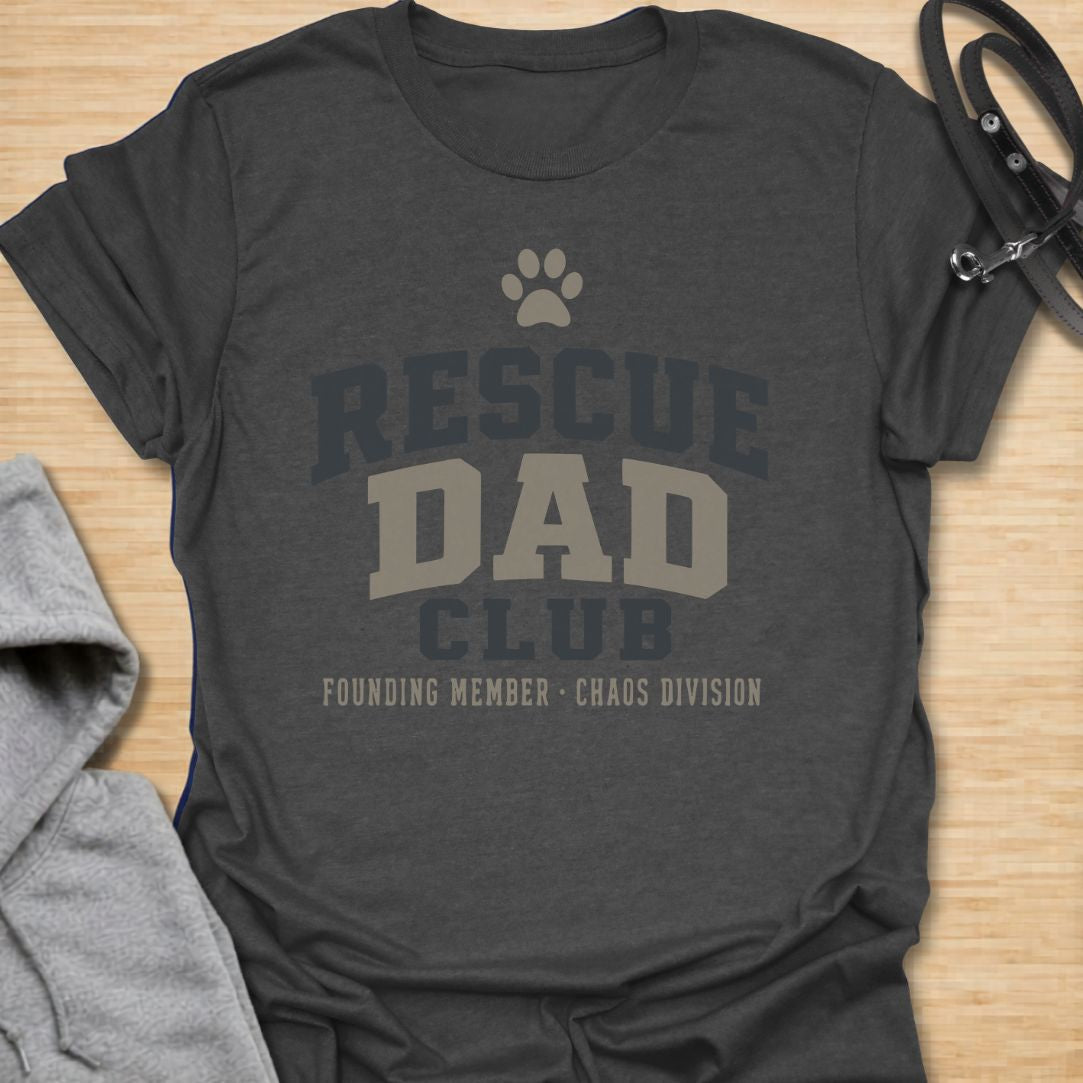 This Rescue Dad Club t-shirt is made for proud dog dads who know rescue dogs bring love, loyalty, and just the right amount of chaos. Featuring bold varsity-style lettering, a paw print, bone accents, and the phrase founding member chaos division, this design has a clean sporty look with a funny rescue-dog twist. Perfect for rescue dog dads, foster dog dads, shelter dog adopters, dog lovers, and anyone proudly raising a second-chance pup.