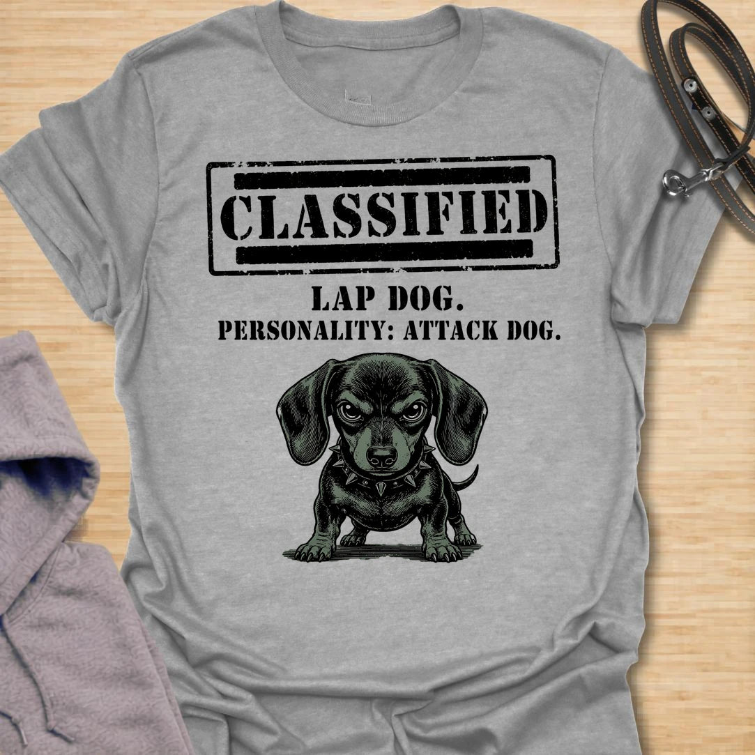 This Classified Lap Dog Personality Attack Dog t-shirt is made for dachshund lovers who know their tiny dog has serious main-character energy. Featuring a classified stamp-style layout, bold text, and a fierce little dachshund illustration, this design has a funny breed-specific attitude that doxie owners will instantly understand. Perfect for dachshund moms, dachshund dads, wiener dog fans, rescue dog lovers, and anyone whose lap dog acts like personal security.