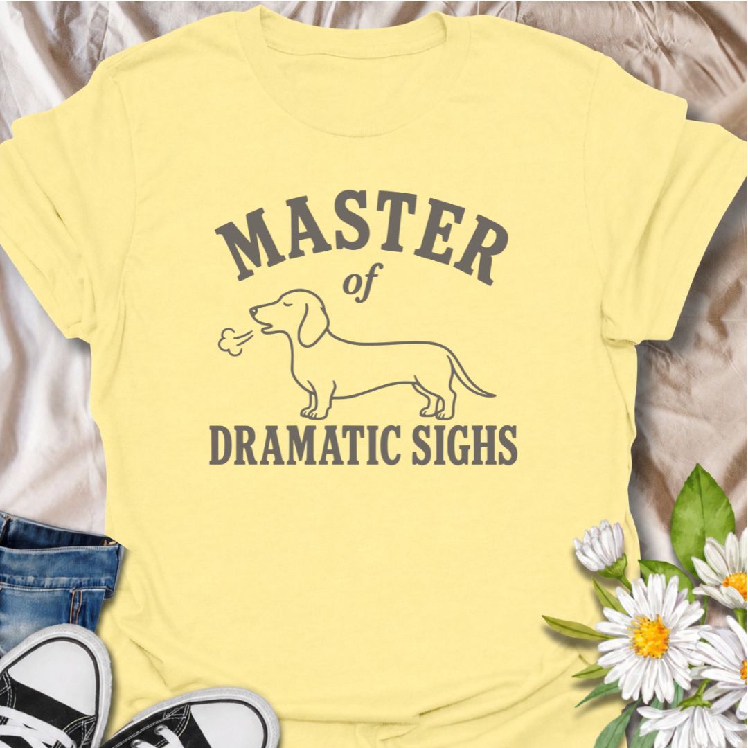 For the dachshund who turns every minor inconvenience into a full performance. This funny dachshund T-shirt features a simple sausage dog illustration with the phrase “Master of Dramatic Sighs.” A playful, easy-to-wear gift for dachshund owners, dog moms, dog dads, and anyone familiar with classic doxie drama.