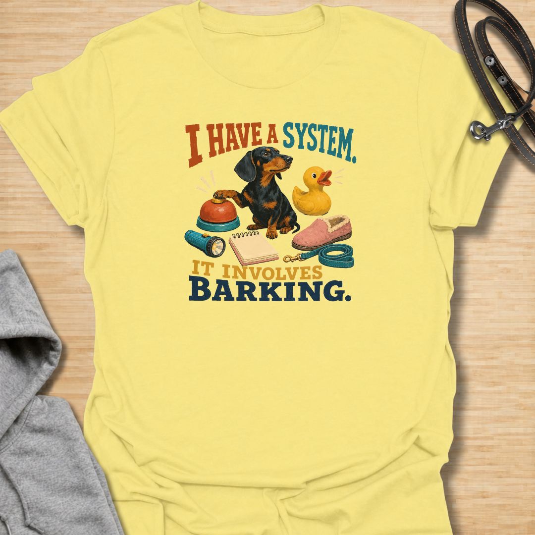 Every dachshund has a system—and it usually involves barking. This funny dachshund T-shirt features a determined sausage dog surrounded by its essential barking equipment, making it perfect for doxie owners who know the routine. A playful everyday tee and a fun gift for dachshund moms, dads, and devoted dog lovers.