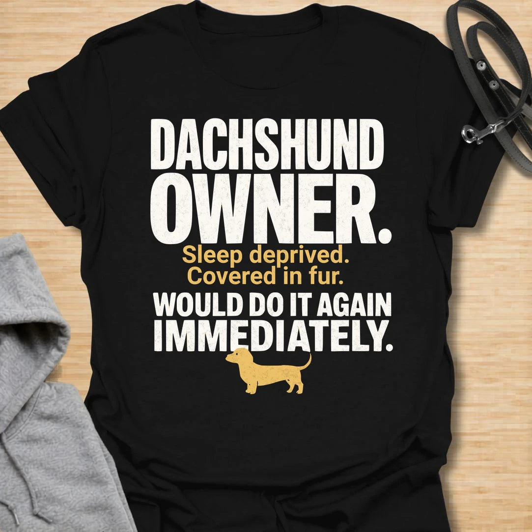 This Dachshund Owner t-shirt is made for doxie lovers who know the tiny legs come with big opinions, endless fur, and questionable sleep. Featuring bold distressed typography, a small dachshund silhouette, and the funny phrase Sleep Deprived. Covered In Fur. Would Do It Again Immediately., this design has a relatable dog-parent feel that dachshund owners will instantly understand. Perfect for dachshund moms, dachshund dads, wiener dog fans, rescue dog lovers, and anyone who knows life with a dachshund is ch