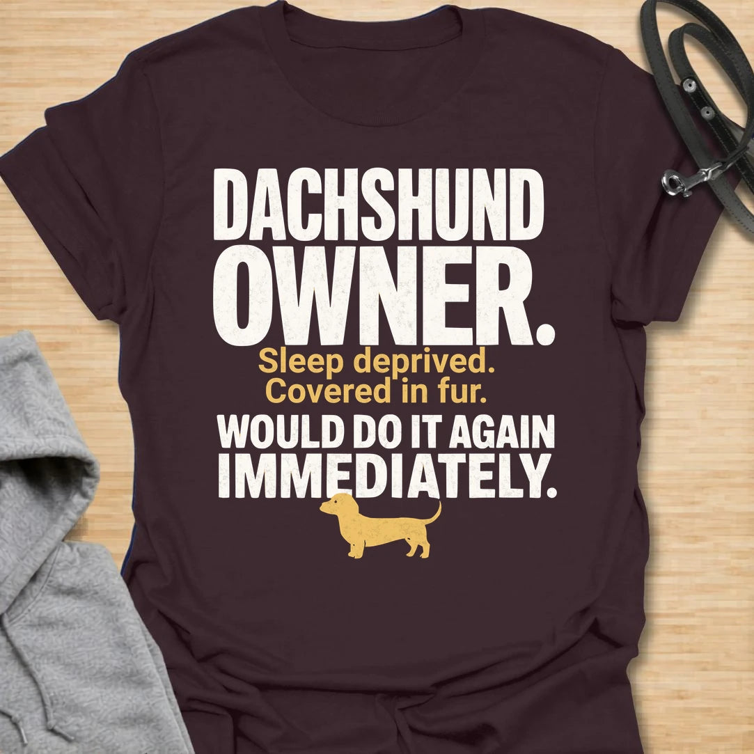 This Dachshund Owner t-shirt is made for doxie lovers who know the tiny legs come with big opinions, endless fur, and questionable sleep. Featuring bold distressed typography, a small dachshund silhouette, and the funny phrase Sleep Deprived. Covered In Fur. Would Do It Again Immediately., this design has a relatable dog-parent feel that dachshund owners will instantly understand. Perfect for dachshund moms, dachshund dads, wiener dog fans, rescue dog lovers, and anyone who knows life with a dachshund is ch