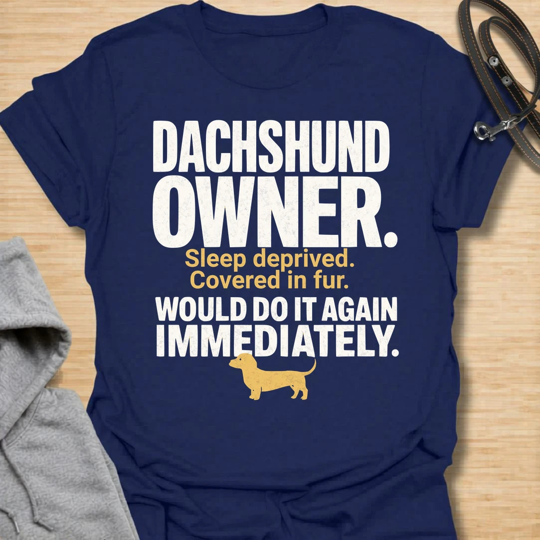This Dachshund Owner t-shirt is made for doxie lovers who know the tiny legs come with big opinions, endless fur, and questionable sleep. Featuring bold distressed typography, a small dachshund silhouette, and the funny phrase Sleep Deprived. Covered In Fur. Would Do It Again Immediately., this design has a relatable dog-parent feel that dachshund owners will instantly understand. Perfect for dachshund moms, dachshund dads, wiener dog fans, rescue dog lovers, and anyone who knows life with a dachshund is ch