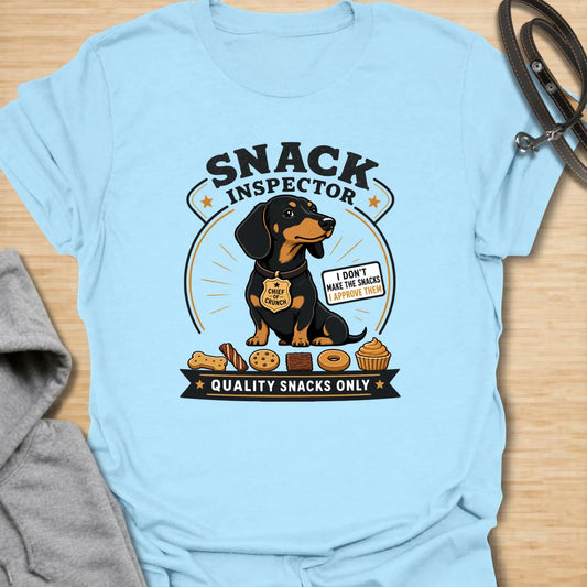 Snack Inspector Dachshund t-shirt for the doxie who takes food quality very seriously. This funny vintage-style design features a dachshund snack inspector with bold badge-style lettering and playful snack details. A perfect gift for dachshund owners whose dog appears the second food is opened. Great for wiener dog lovers, sausage dog fans, and anyone living with a professional crumb detective.