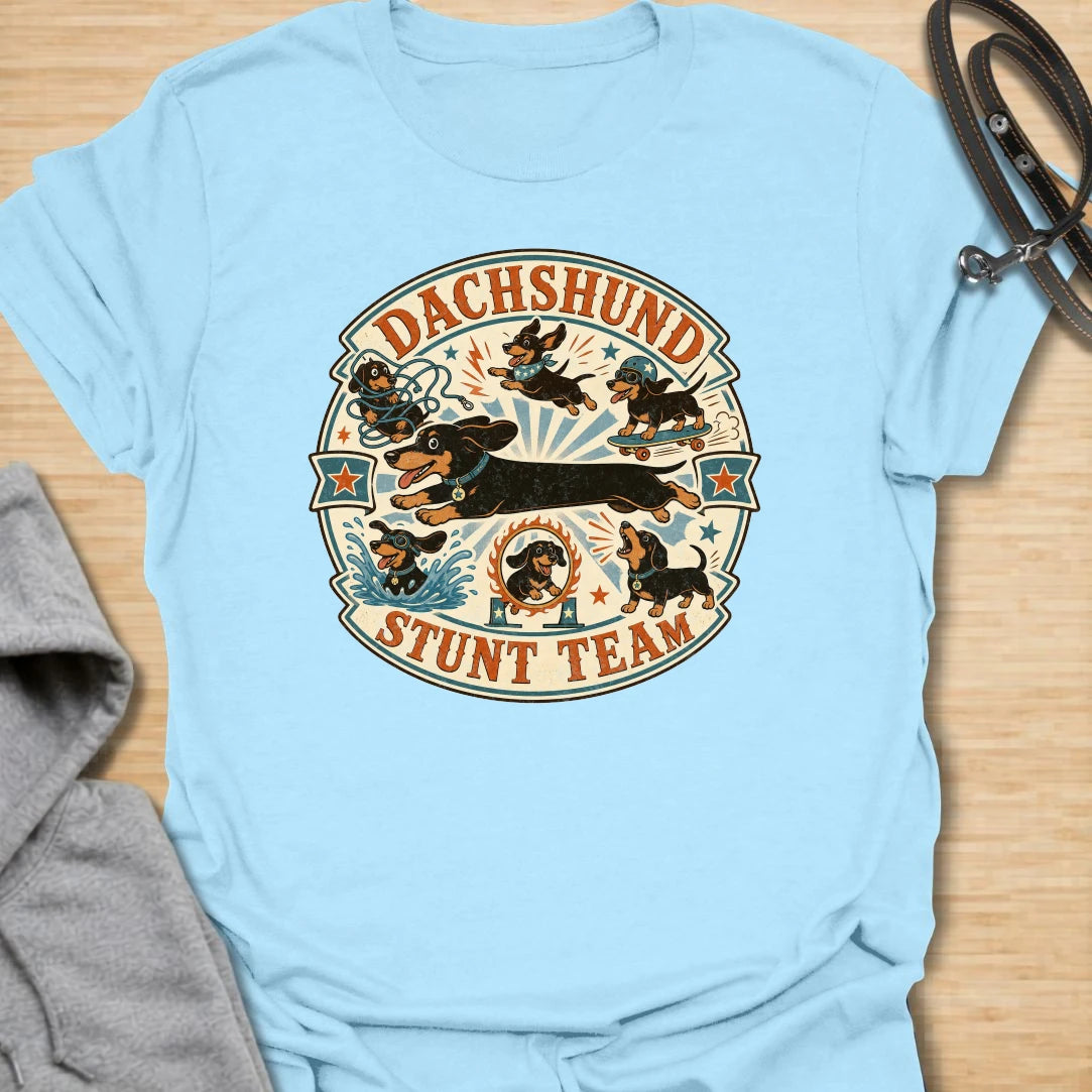 Dachshund Stunt Team t-shirt for sausage dog lovers who know dachshunds treat everyday life like an extreme sport. This vintage circus-style design features adventurous doxies jumping, skating, splashing, barking, and causing chaos. Perfect for dachshund moms, doxie dads, and anyone who loves playful wiener dog humor.