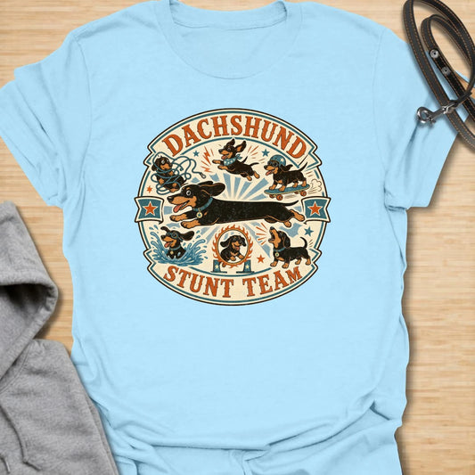 Dachshund Stunt Team t-shirt for sausage dog lovers who know dachshunds treat everyday life like an extreme sport. This vintage circus-style design features adventurous doxies jumping, skating, splashing, barking, and causing chaos. Perfect for dachshund moms, doxie dads, and anyone who loves playful wiener dog humor.