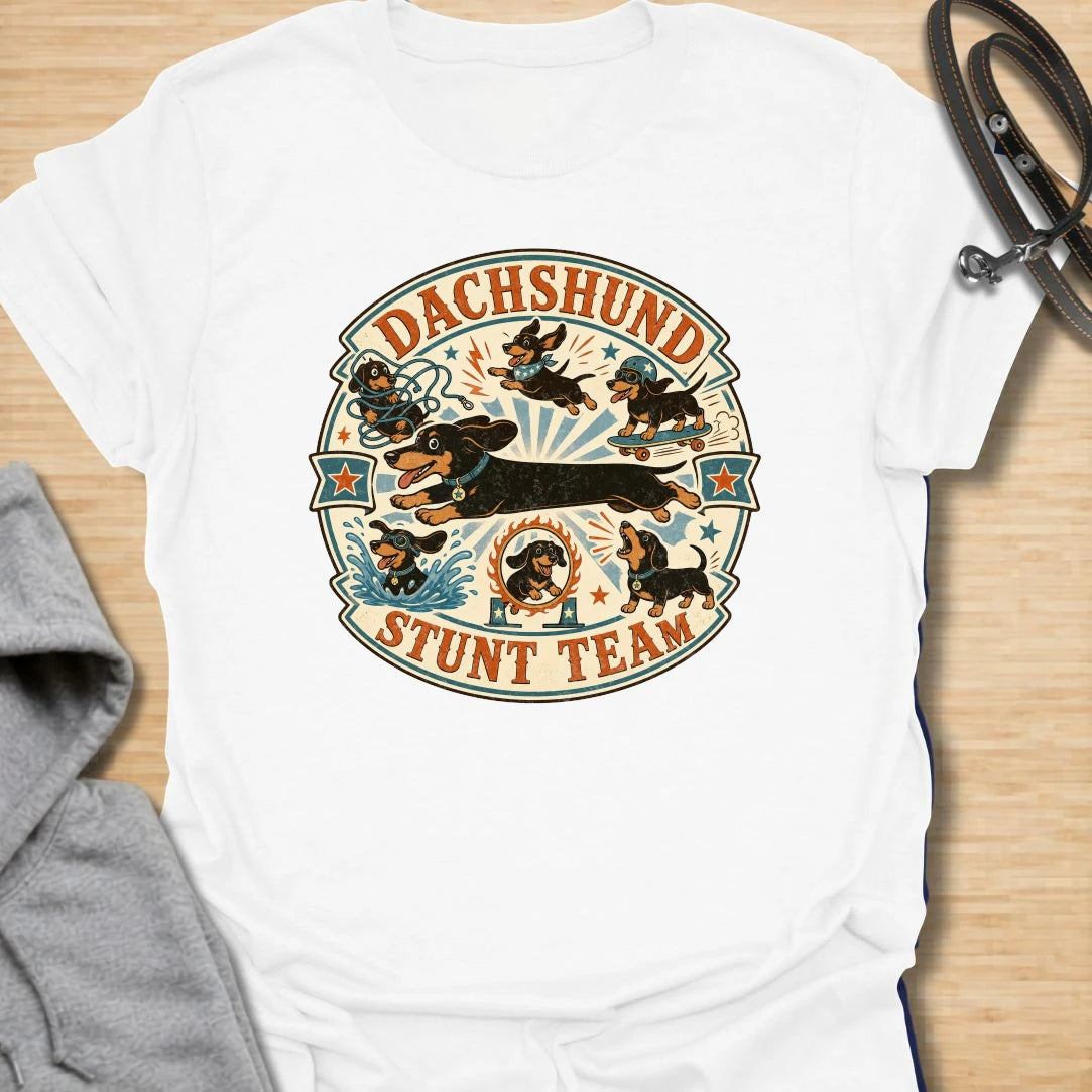 Dachshund Stunt Team t-shirt for sausage dog lovers who know dachshunds treat everyday life like an extreme sport. This vintage circus-style design features adventurous doxies jumping, skating, splashing, barking, and causing chaos. Perfect for dachshund moms, doxie dads, and anyone who loves playful wiener dog humor.