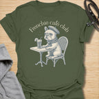This Frenchie Café Club t-shirt is made for French Bulldog lovers who enjoy a little café charm with their dog-parent style. Featuring a vintage-style Frenchie sitting at a bistro table with a drink and beret, this design has a refined, playful feel with classic French café personality. Perfect for Frenchie moms, Frenchie dads, French Bulldog owners, coffee lovers, café fans, and anyone who loves their small dog with a side of attitude.