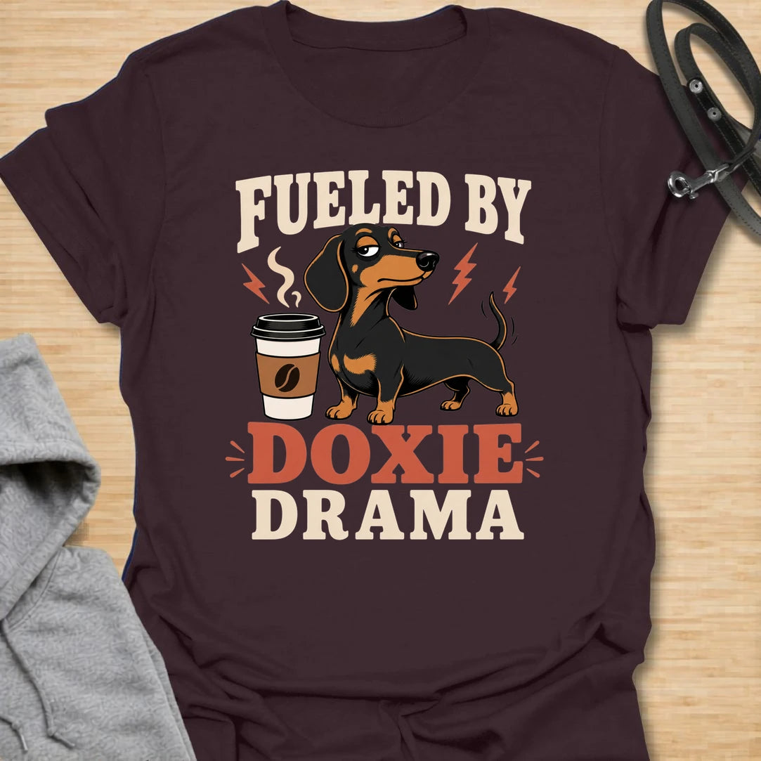 This Fueled By Doxie Drama t-shirt is made for dachshund lovers who know their little long dog brings attitude, opinions, and daily entertainment. Featuring a sassy black and tan dachshund with a coffee cup, bold retro lettering, and playful lightning details, this funny dog design is great for dachshund moms, dachshund dads, coffee lovers, wiener dog fans, and anyone powered by caffeine and doxie chaos.