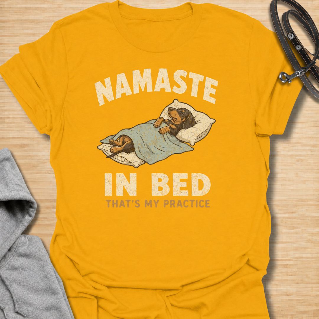 Celebrate the dachshund approach to yoga with this funny “Namaste in Bed” T-shirt. Featuring a cozy sausage dog tucked beneath the blankets with the phrase “That’s My Practice,” it is perfect for dachshund moms, dog dads, homebodies, and yoga lovers. A playful gift for anyone who prefers relaxation, naps, and staying comfortably in bed.