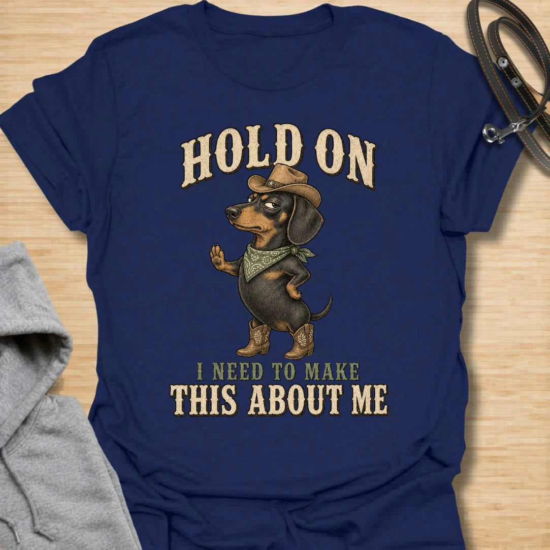 This Hold On I Need To Make This About Me t-shirt is made for dachshund lovers who know their little long dog must be the center of every conversation. Featuring a western-style dachshund in a hat, boots, and bandana with bold vintage lettering, this design has a funny main-character dog-parent feel. Perfect for dachshund moms, dachshund dads, wiener dog fans, rescue dog lovers, and anyone whose doxie always steals the spotlight.