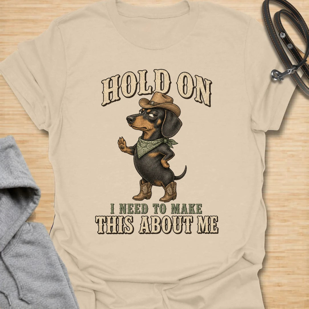 This Hold On I Need To Make This About Me t-shirt is made for dachshund lovers who know their little long dog must be the center of every conversation. Featuring a western-style dachshund in a hat, boots, and bandana with bold vintage lettering, this design has a funny main-character dog-parent feel. Perfect for dachshund moms, dachshund dads, wiener dog fans, rescue dog lovers, and anyone whose doxie always steals the spotlight.