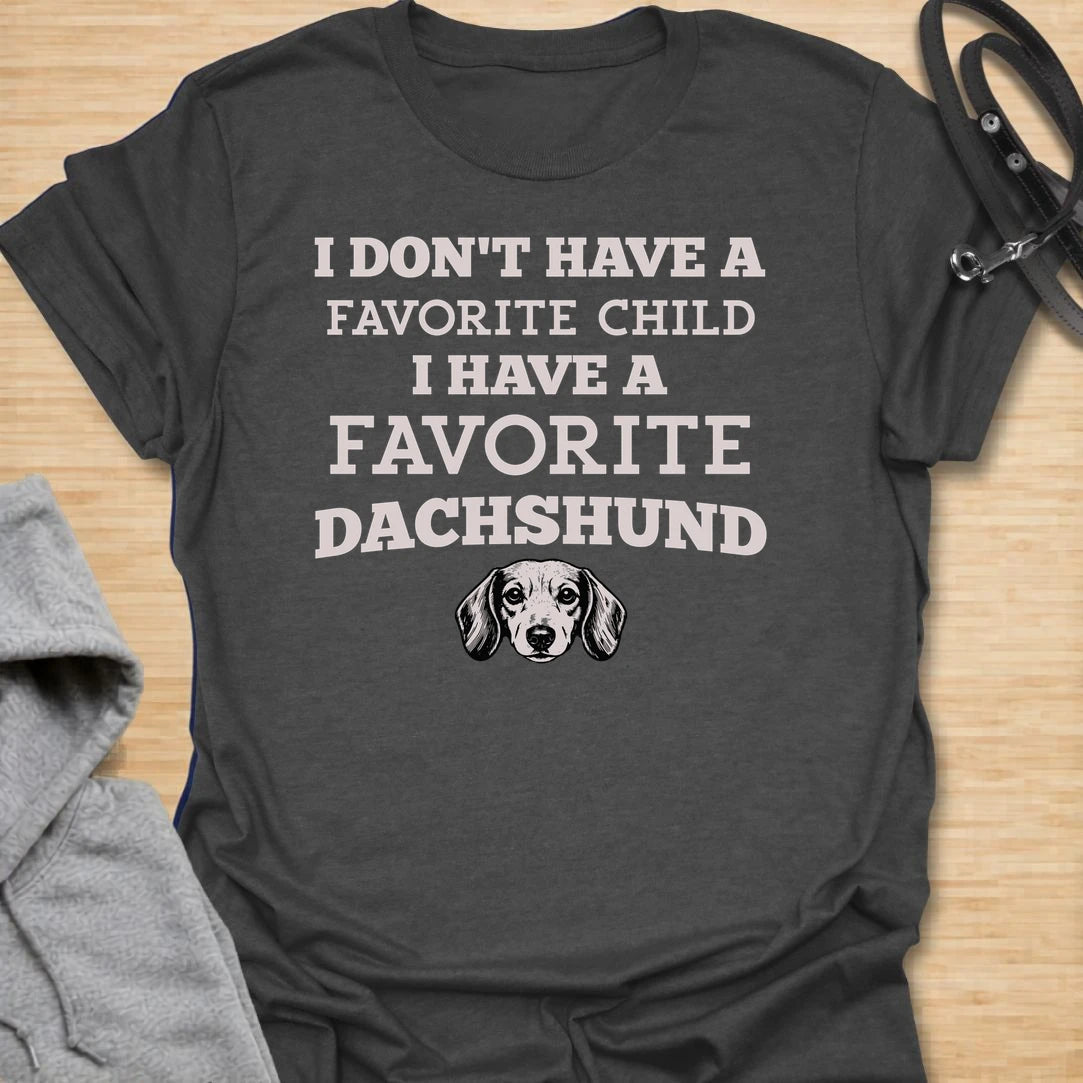 This I Have A Favorite Dachshund t-shirt is made for doxie lovers who know exactly where their loyalty lies. Featuring bold vintage-style typography, a small dachshund face illustration, and the funny phrase I Don’t Have A Favorite Child I Have A Favorite Dachshund, this design has a playful dog-parent feel that wiener dog fans will instantly understand. Perfect for dachshund moms, dachshund dads, doxie owners, rescue dog lovers, and anyone whose favorite family member has tiny legs and a long body.