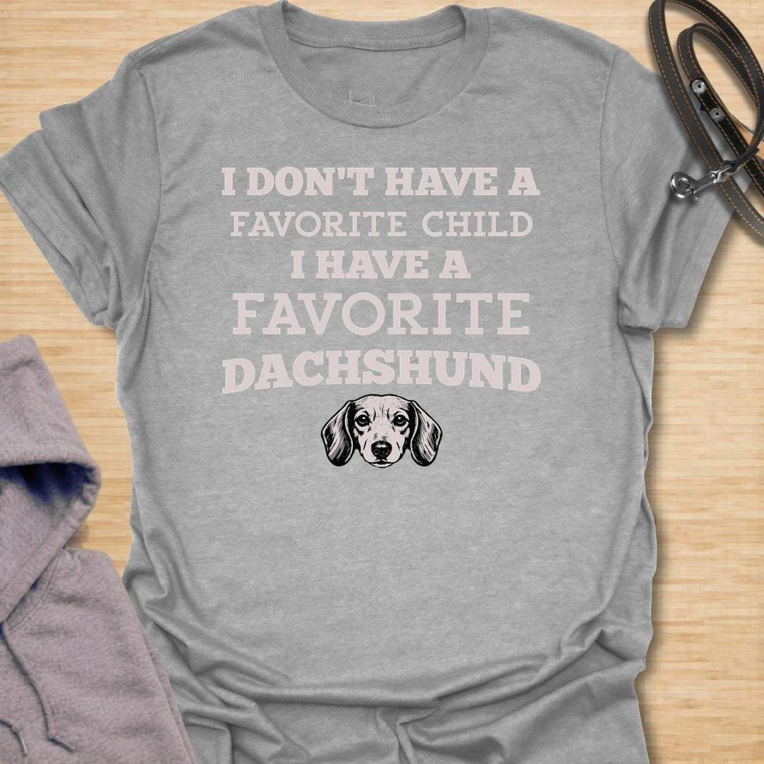 This I Have A Favorite Dachshund t-shirt is made for doxie lovers who know exactly where their loyalty lies. Featuring bold vintage-style typography, a small dachshund face illustration, and the funny phrase I Don’t Have A Favorite Child I Have A Favorite Dachshund, this design has a playful dog-parent feel that wiener dog fans will instantly understand. Perfect for dachshund moms, dachshund dads, doxie owners, rescue dog lovers, and anyone whose favorite family member has tiny legs and a long body.