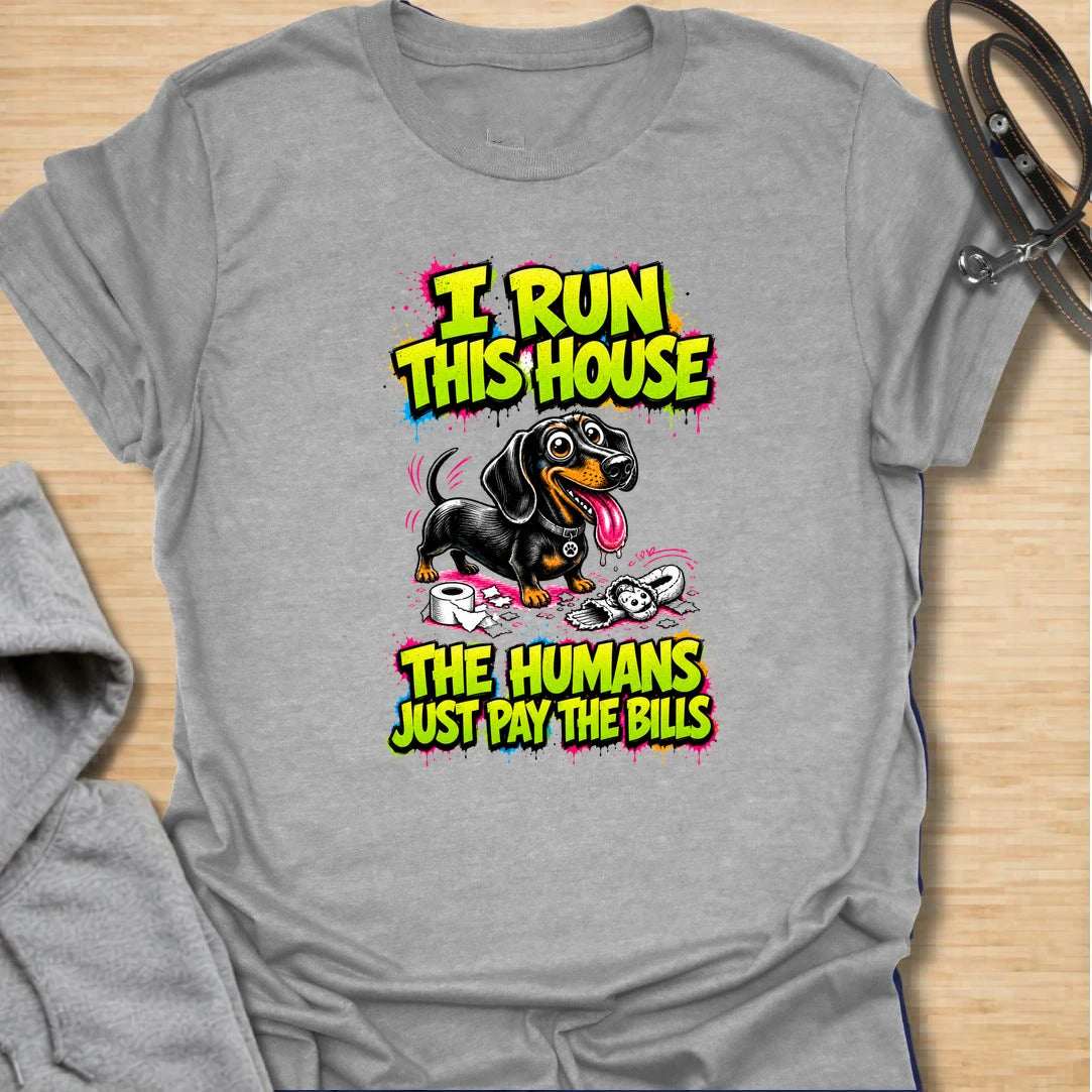 Run This House t-shirt for dachshund lovers who know the smallest dog in the home is usually the one in charge. This bold comic-style design features a mischievous doxie and the phrase “I Run This House The Humans Just Pay The Bills.” Perfect for sausage dog owners, doxie moms, and anyone whose dog rules the household.