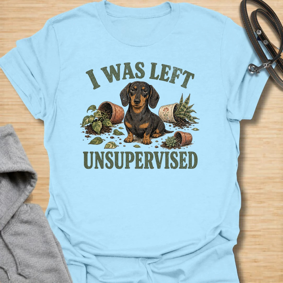 This I Was Left Unsupervised t-shirt is made for dachshund lovers who know their little long dog can create a whole disaster in record time. Featuring a guilty-looking dachshund surrounded by knocked-over plant pots and soil, this design has a funny chaotic dog-parent feel. Perfect for dachshund moms, dachshund dads, wiener dog fans, rescue dog lovers, plant lovers, and anyone whose doxie cannot be trusted alone.