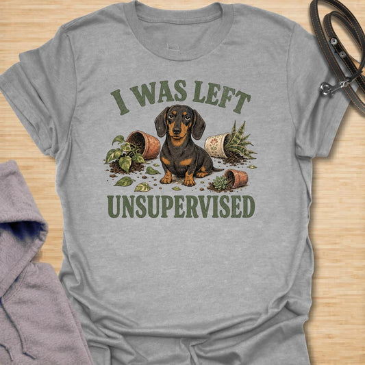 This I Was Left Unsupervised t-shirt is made for dachshund lovers who know their little long dog can create a whole disaster in record time. Featuring a guilty-looking dachshund surrounded by knocked-over plant pots and soil, this design has a funny chaotic dog-parent feel. Perfect for dachshund moms, dachshund dads, wiener dog fans, rescue dog lovers, plant lovers, and anyone whose doxie cannot be trusted alone.