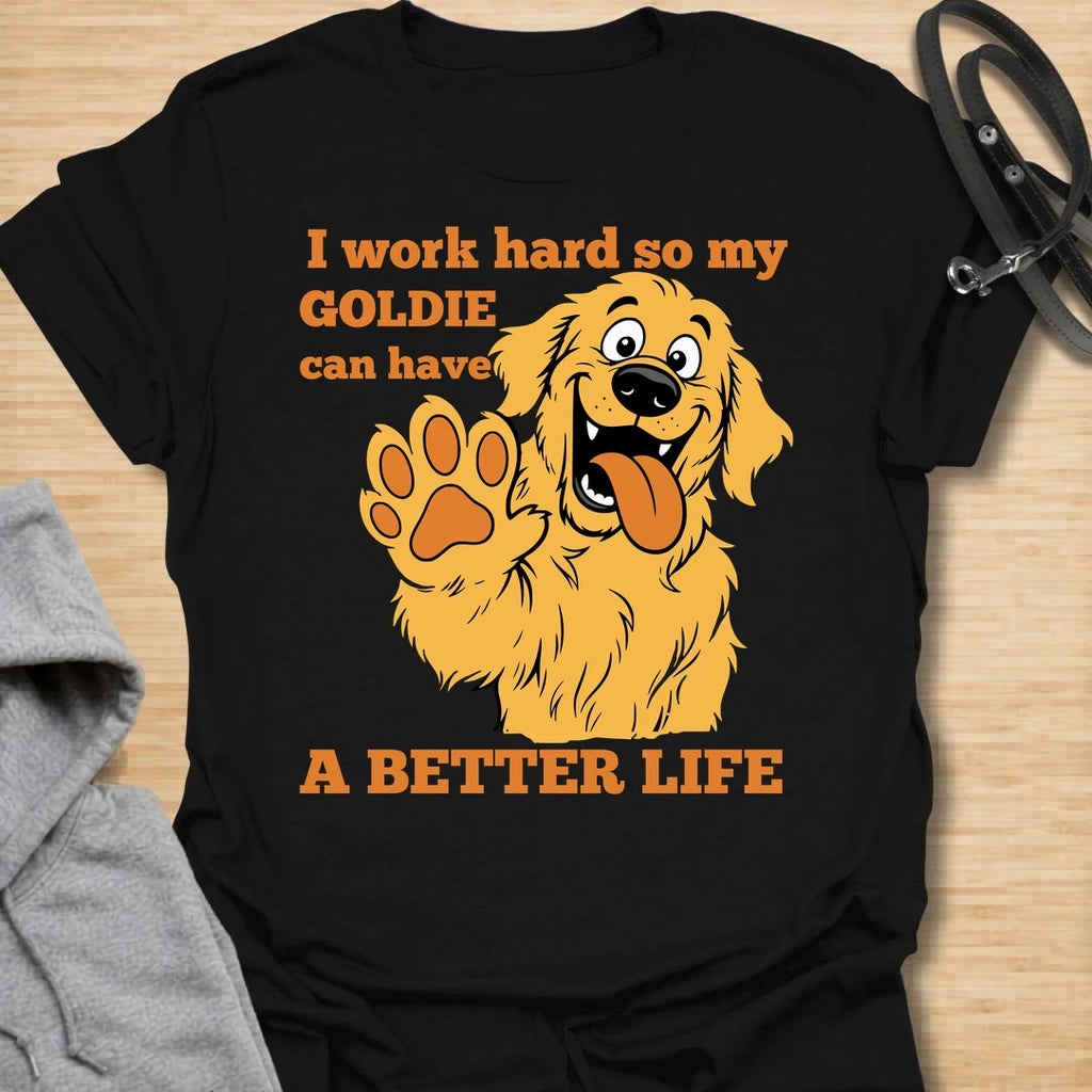 This I Work Hard So My Goldie Can Have A Better Life t-shirt is made for Golden Retriever owners who know exactly where their money, time, and attention really go. Featuring a happy cartoon Goldie with a big smile, raised paw, and playful bold lettering, this design has a funny, lovable dog-parent feel. Perfect for Golden Retriever moms, Golden Retriever dads, Goldie lovers, rescue dog owners, and anyone who proudly spoils their golden best friend. Black