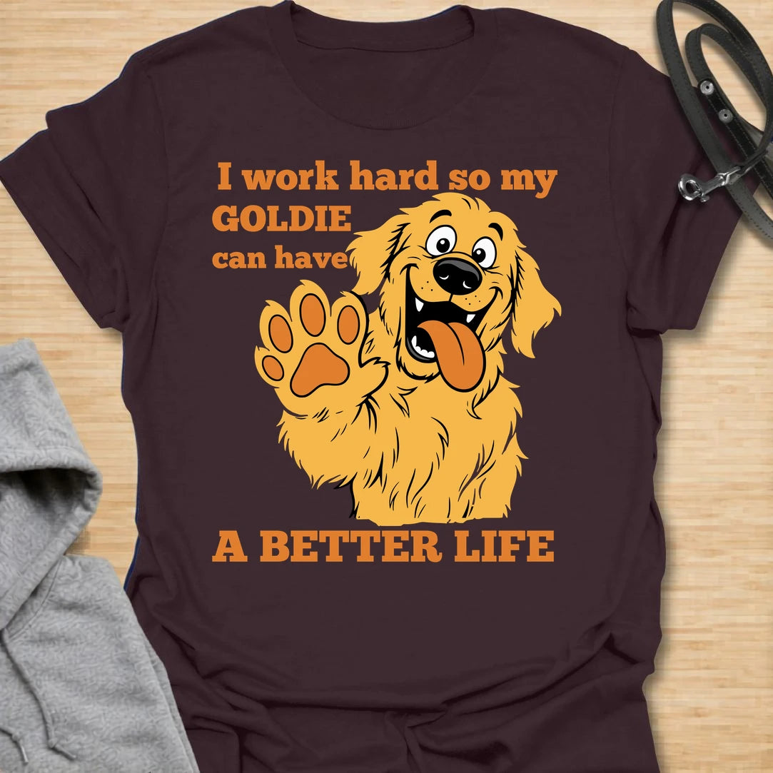 This I Work Hard So My Goldie Can Have A Better Life t-shirt is made for Golden Retriever owners who know exactly where their money, time, and attention really go. Featuring a happy cartoon Goldie with a big smile, raised paw, and playful bold lettering, this design has a funny, lovable dog-parent feel. Perfect for Golden Retriever moms, Golden Retriever dads, Goldie lovers, rescue dog owners, and anyone who proudly spoils their golden best friend. Dark Chocolate