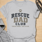 This Rescue Dad Club t-shirt is made for proud dog dads who know rescue dogs bring love, loyalty, and just the right amount of chaos. Featuring bold varsity-style lettering, a paw print, bone accents, and the phrase founding member chaos division, this design has a clean sporty look with a funny rescue-dog twist. Perfect for rescue dog dads, foster dog dads, shelter dog adopters, dog lovers, and anyone proudly raising a second-chance pup.