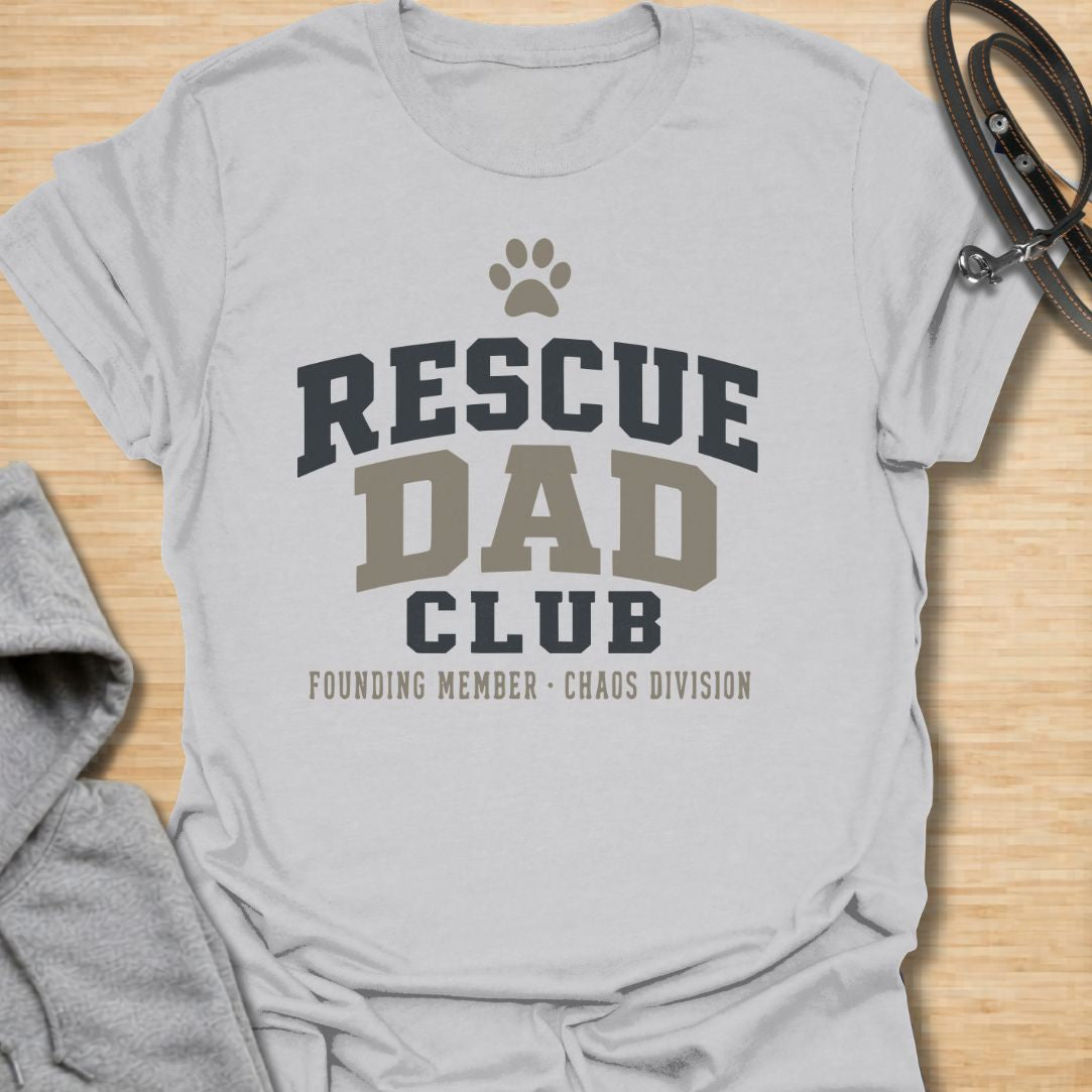 This Rescue Dad Club t-shirt is made for proud dog dads who know rescue dogs bring love, loyalty, and just the right amount of chaos. Featuring bold varsity-style lettering, a paw print, bone accents, and the phrase founding member chaos division, this design has a clean sporty look with a funny rescue-dog twist. Perfect for rescue dog dads, foster dog dads, shelter dog adopters, dog lovers, and anyone proudly raising a second-chance pup.
