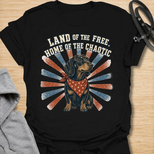 This Land Of The Free Home Of The Chaotic t-shirt is made for dachshund lovers who know their little long dog brings big energy everywhere they go. Featuring a black and tan doxie with a red bandana, vintage patriotic-style rays, and bold distressed text, this funny dog design is great for dachshund moms, dachshund dads, wiener dog fans, rescue dog lovers, and anyone whose home is proudly ruled by dachshund chaos.