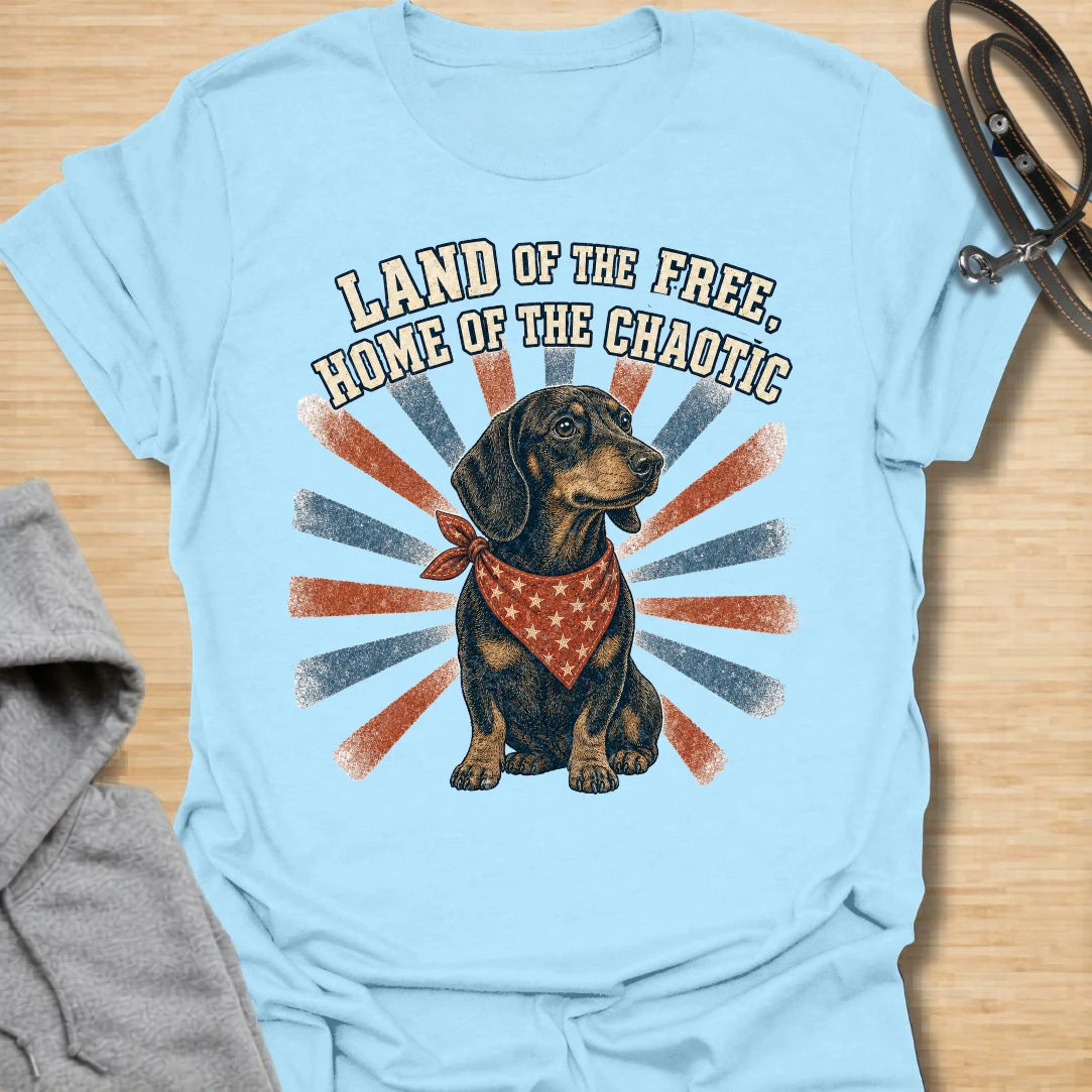 This Land Of The Free Home Of The Chaotic t-shirt is made for dachshund lovers who know their little long dog brings big energy everywhere they go. Featuring a black and tan doxie with a red bandana, vintage patriotic-style rays, and bold distressed text, this funny dog design is great for dachshund moms, dachshund dads, wiener dog fans, rescue dog lovers, and anyone whose home is proudly ruled by dachshund chaos.
